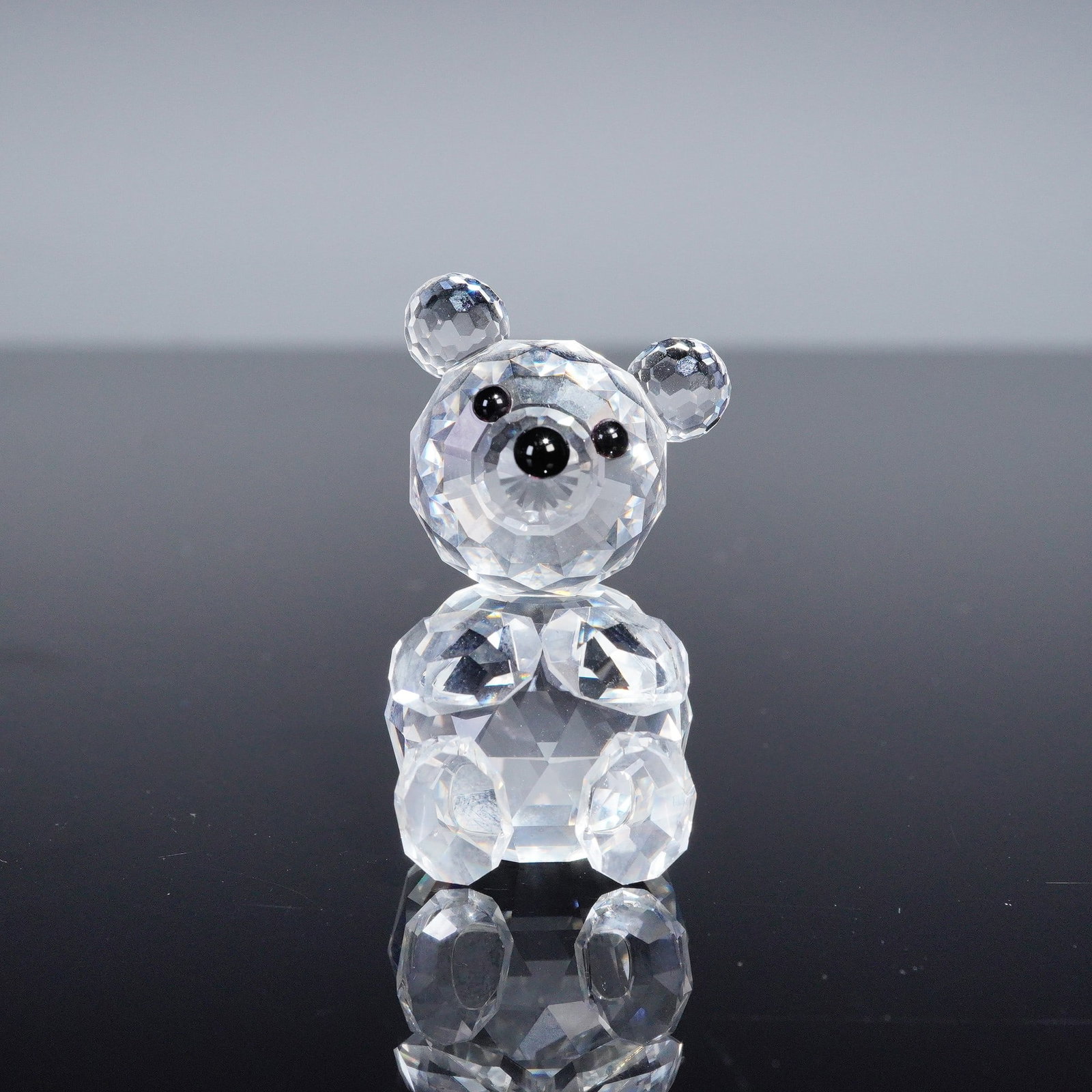 Swarovski Crystal Figurine, Bear: Shown here is a Swarovski crystal figurine of a bear, created in clear faceted crystal with round ears, black crystal eyes, and nose. The piece is hallmarked and offered with its original box, an ende