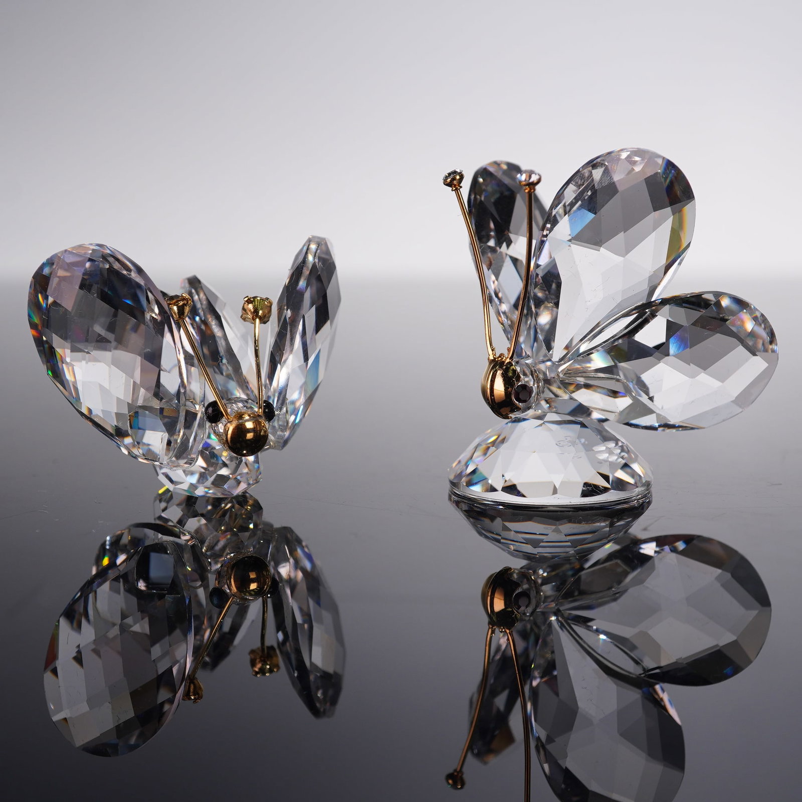 2pc Swarovski Crystal Figurines, Butterflies with Gold Antennae: Pair of Swarovski crystal butterfly figurines, each hallmarked with the Swarovski swan logo and offered with original boxes. Both are crafted with faceted wings that catch the light beautifully, accen