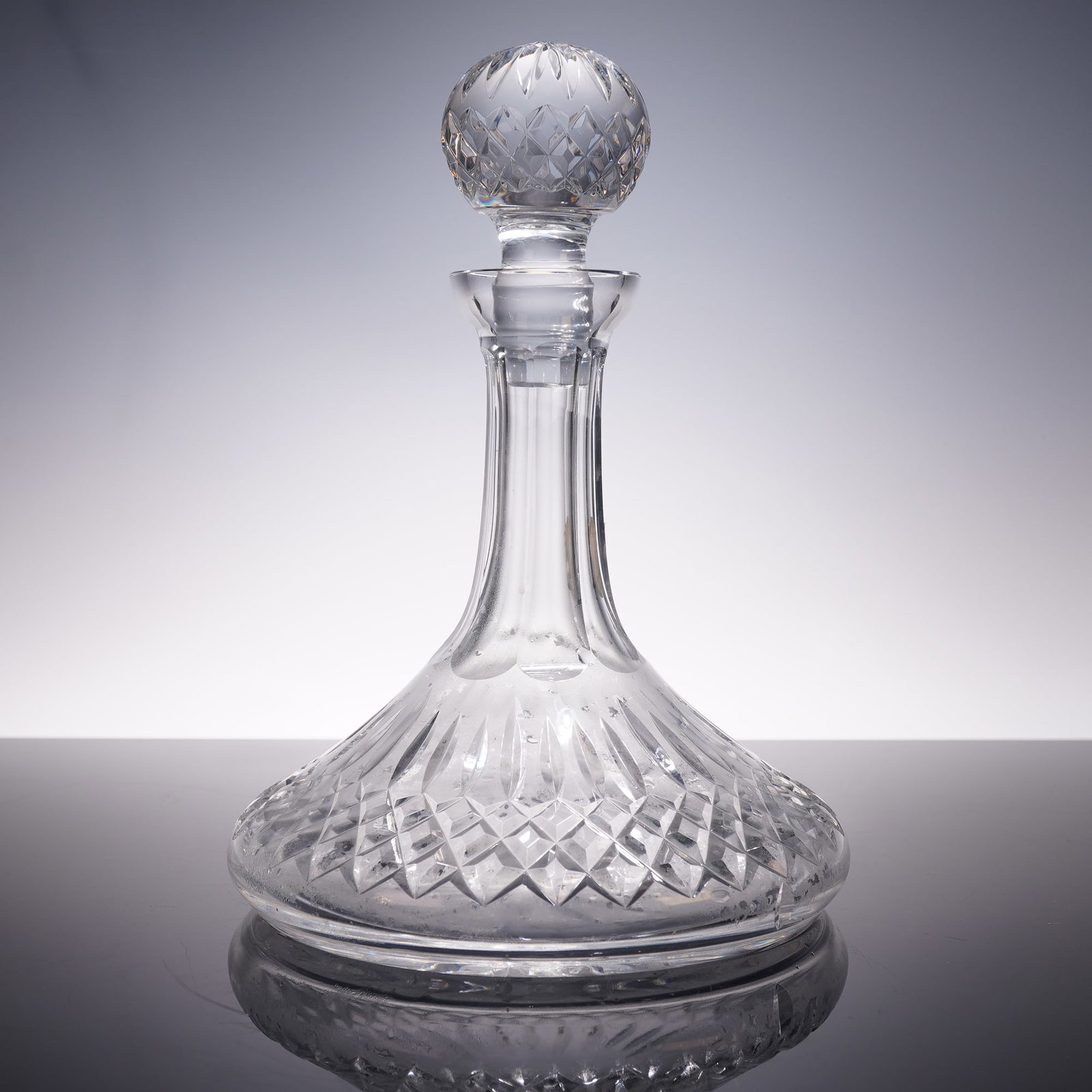 Waterford Crystal Ships Decanter, Lismore: A fine Waterford Crystal decanter in the classic Lismore pattern, featuring a bulbous base with diamond and wedge cut decoration, tapering neck, and matching cut ball stopper. Retains original green a