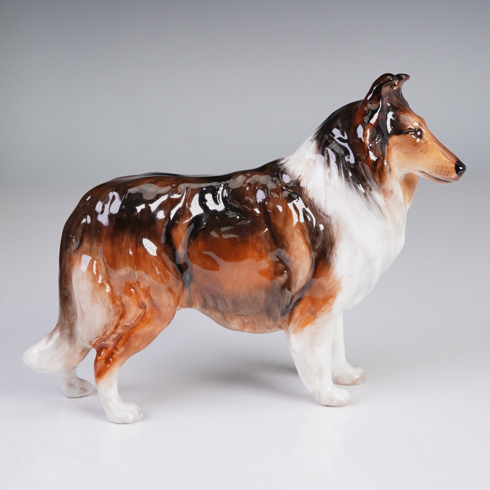 Royal Doulton Figurine Collie HN1059 Small: This stunning Collie figurine from Royal Doulton was designed by Frederick Daws and was issued between 1931 and 1969. It features the graceful and proud stance of the Collie, rendered in rich brown an