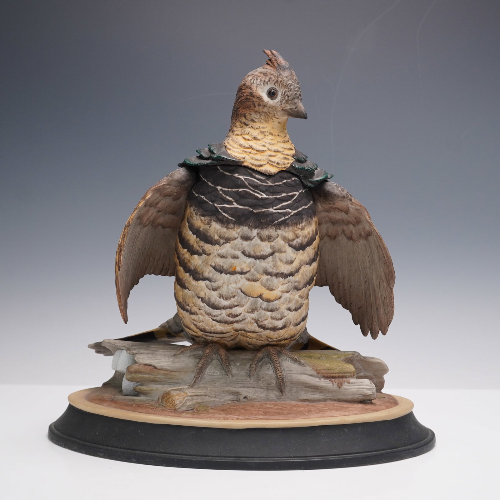 Boehm Porcelain Figurine, Ruffed Grouse: A finely detailed porcelain bird figure depicting a ruffed grouse with wings outstretched in a courtship display. This delicacy is modeled with naturalistic plumage in variegated tones of brown, cream