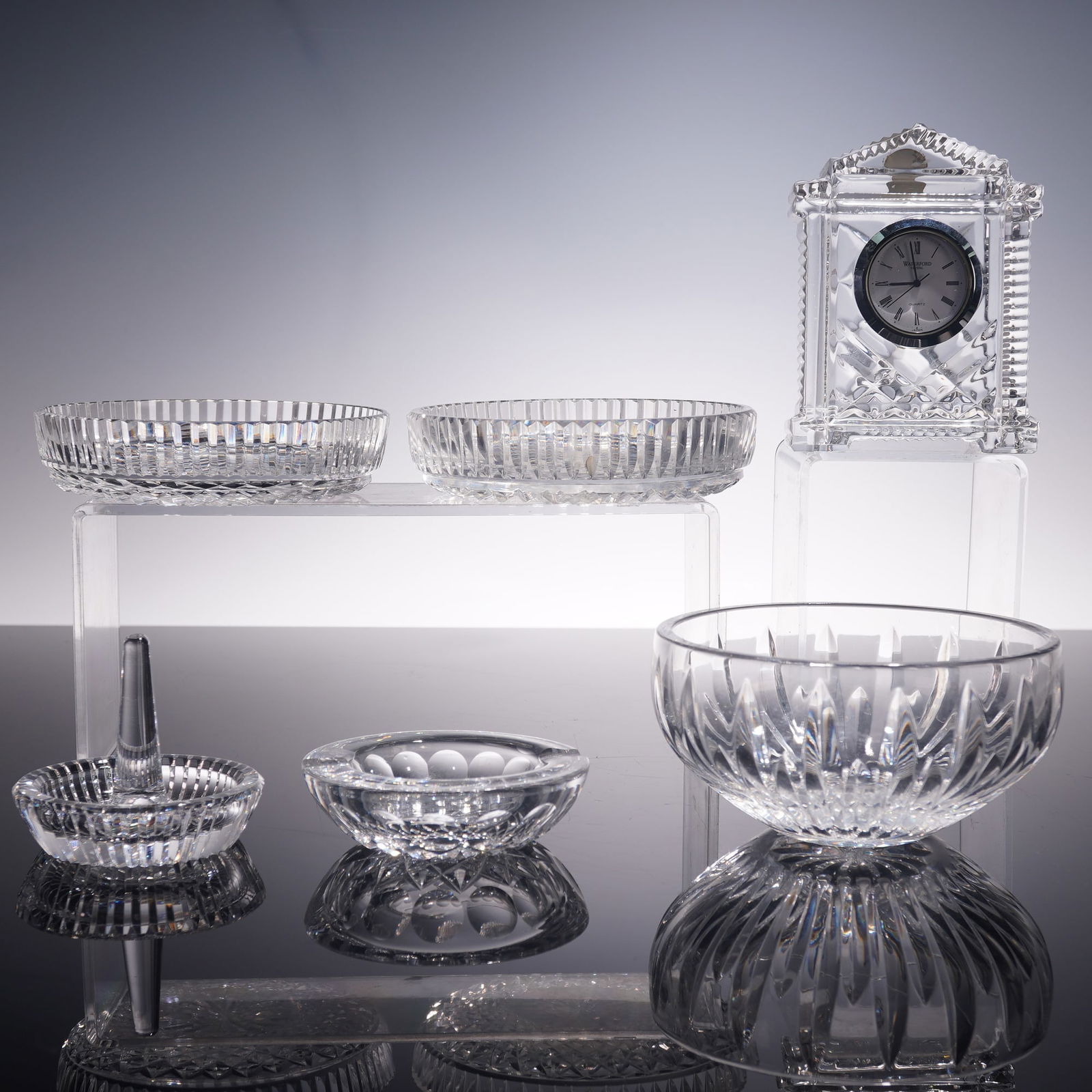 6pc Waterford Crystal Desk and Vanity Accessories Collection: A six piece collection of Waterford crystal desk and table accessories comprising a cut crystal mantle clock, a ring holder, a small round bowl with vertical cut design, a shallow dish, and two oval d