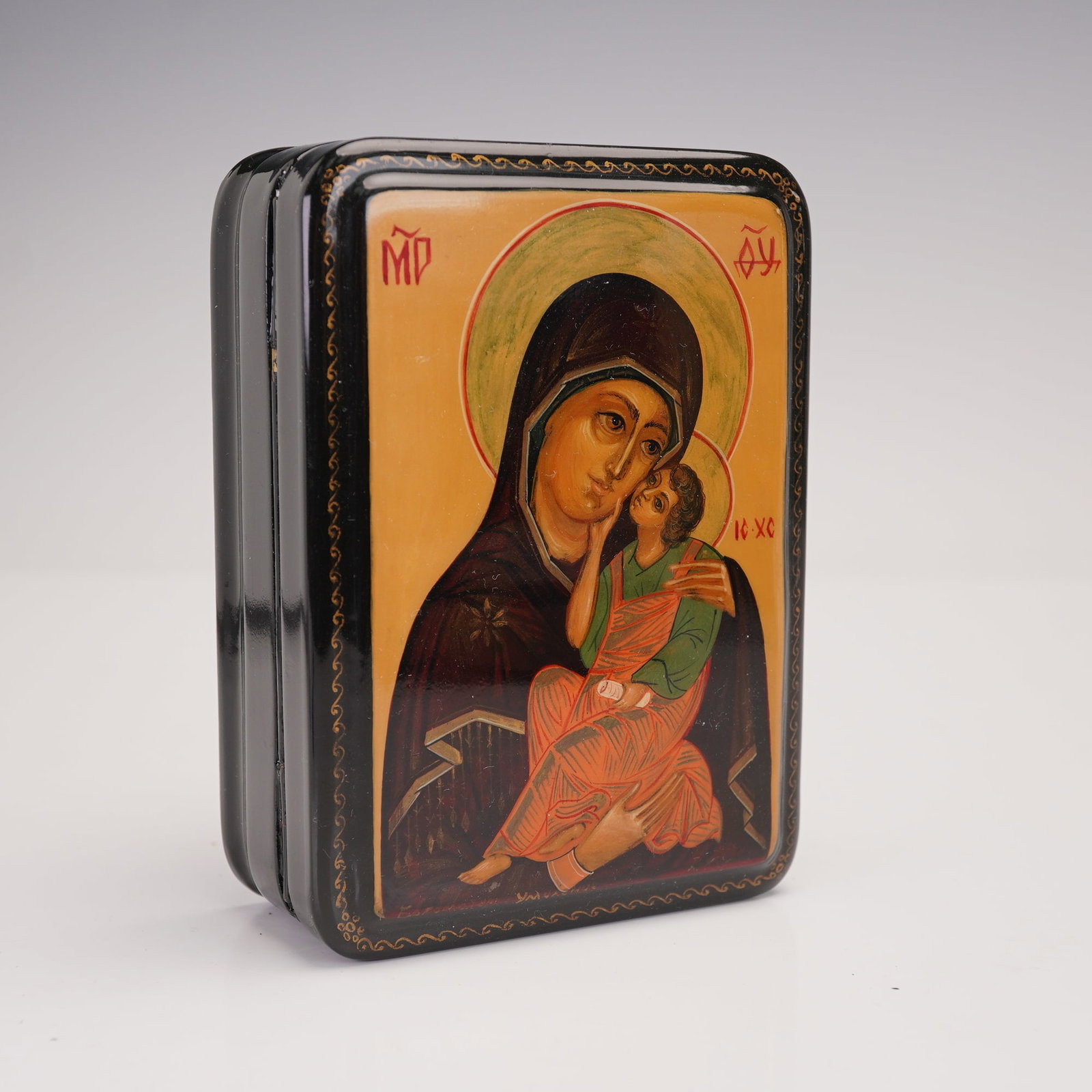 Russian Vintage Virgin of Vladimir Lacquer Box: This hinged rectangular box is crafted in papier-Mache with a glossy black exterior and vibrant red lacquered interior. The lid features a detailed image of the Madonna and Child, with Cyrillic inscri