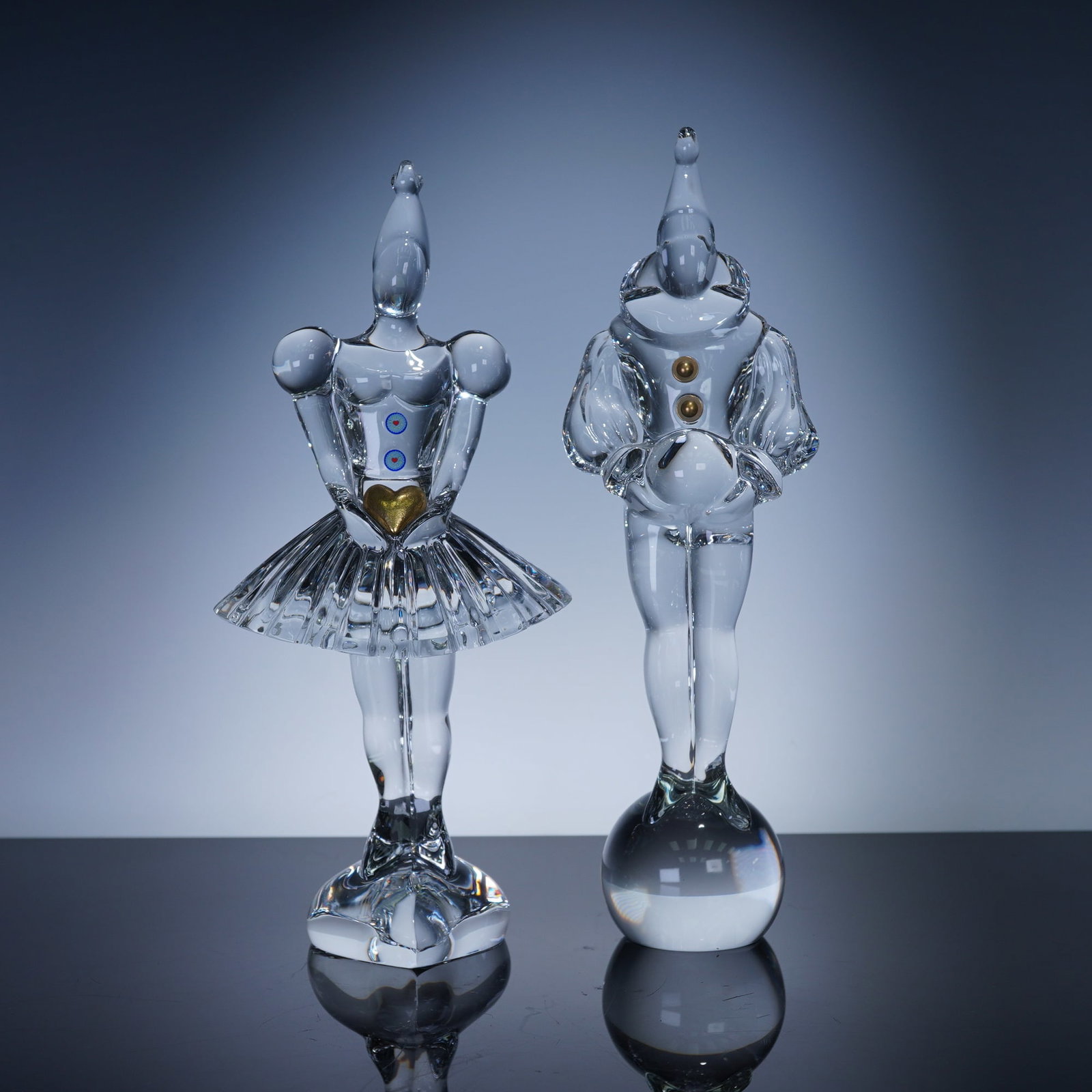 2pc Baccarat Crystal Masquerade Pierrot & Columbine Figurines: Pair of Baccarat crystal figurines from the Masquerade collection, depicting Pierrot and Columbine in elegant carnival costumes. Each figure is finely crafted with brilliant clarity and accented with 