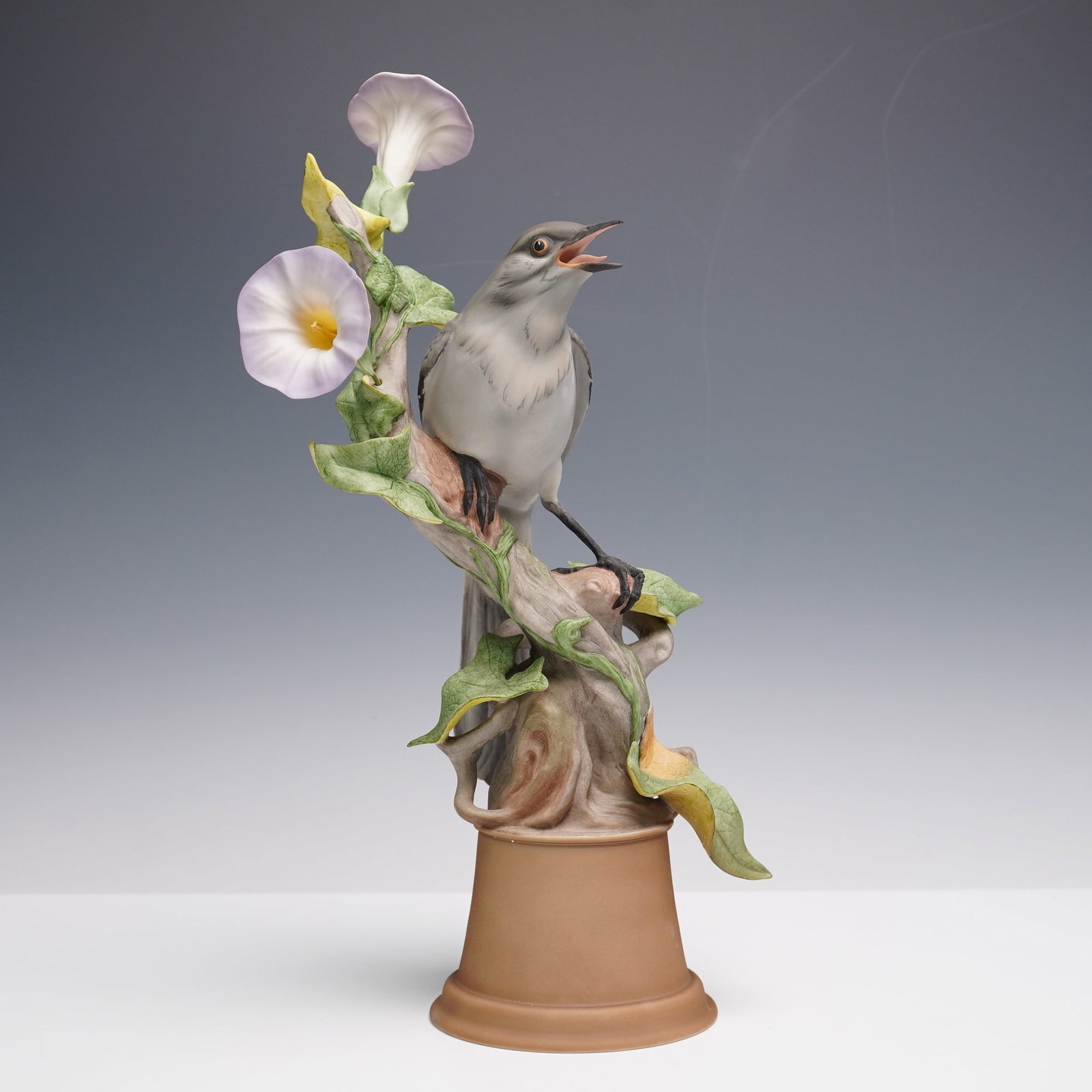 Boehm Porcelain Figurine, Mockingbirds 459G: Produced as part of a limited edition collection. The piece is hand-painted and depicts a finely modeled mockingbird perched on a tree branch with open beak, surrounded by sculpted foliage and trumpet