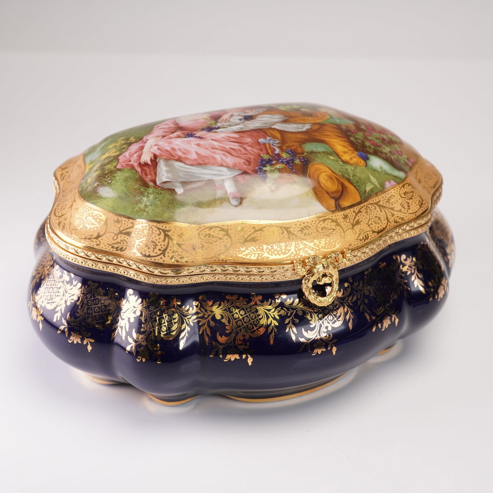 Imperial Limoges French Porcelain Hinged Box, Hand-Painted Scene, Gold Gilt: This exquisite hinged box from Imperial Limoges is crafted from fine French porcelain, showcasing a beautifully hand-painted scene of a couple in a romantic garden setting. The vibrant colors and fine