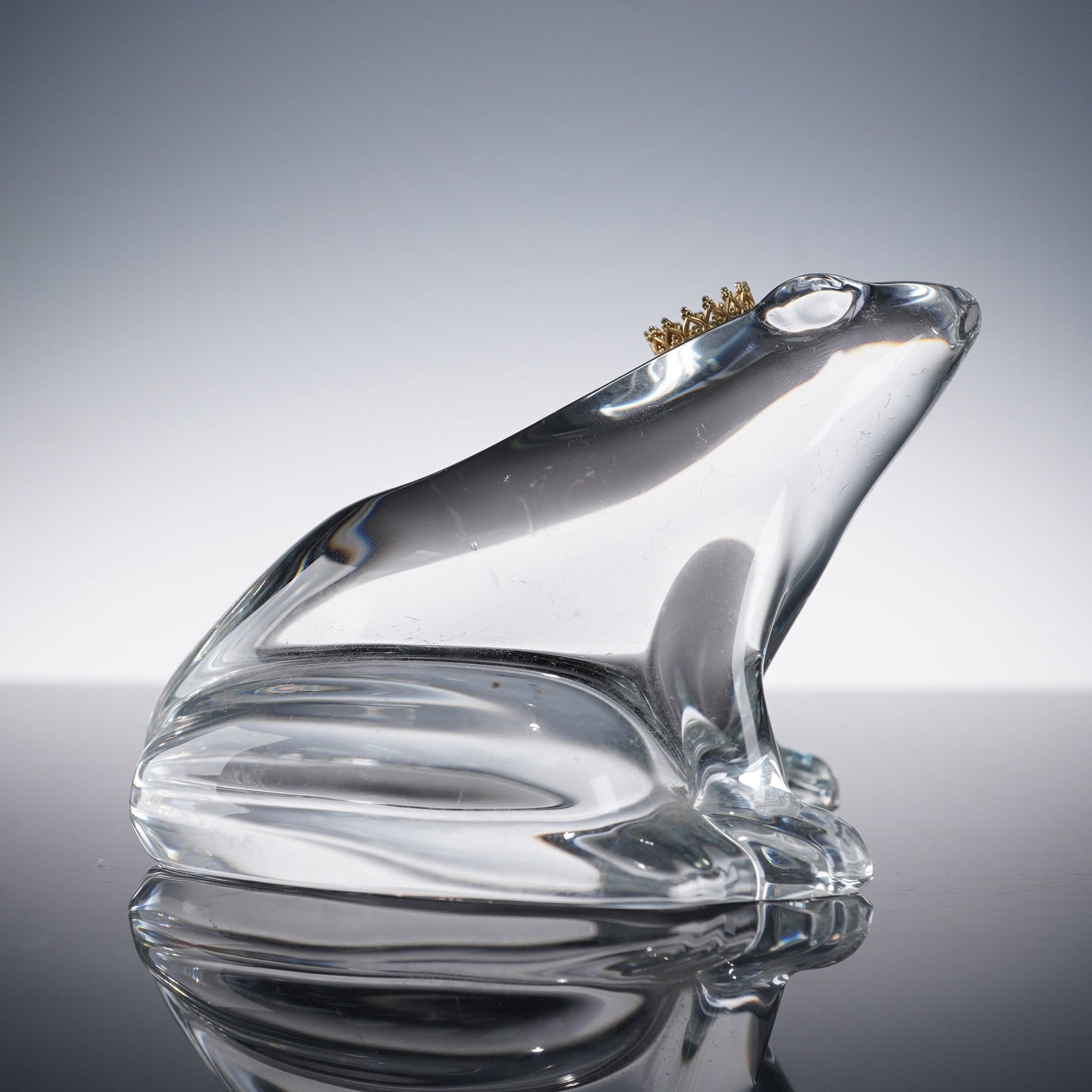 Baccarat Crystal Paperweight, Frog Prince: Clear Baccarat crystal paperweight in the form of a seated frog, topped with a delicate gilt metal crown. A finely sculpted example of Baccarat craftsmanship, this whimsical design evokes the fairy ta