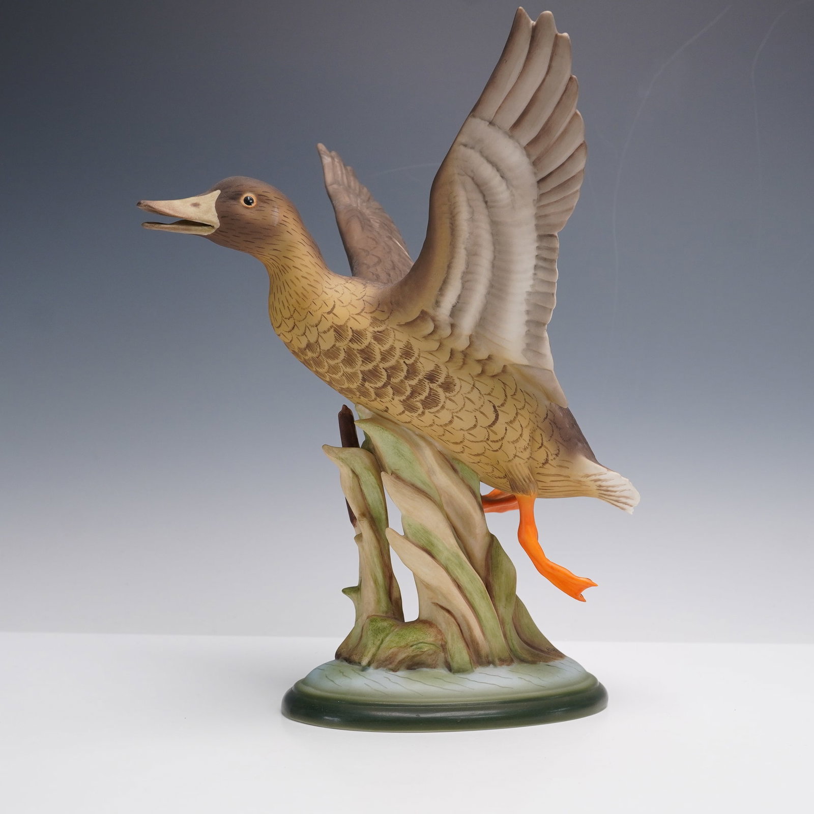 Boehm Porcelain Figurine, Mallards 406E: Impeccable, limited edition figurine depicting a mallard hen in flight, wings outstretched above a sculpted base of cattails and marsh grasses. The bird is painted in mottled brown plumage with finely