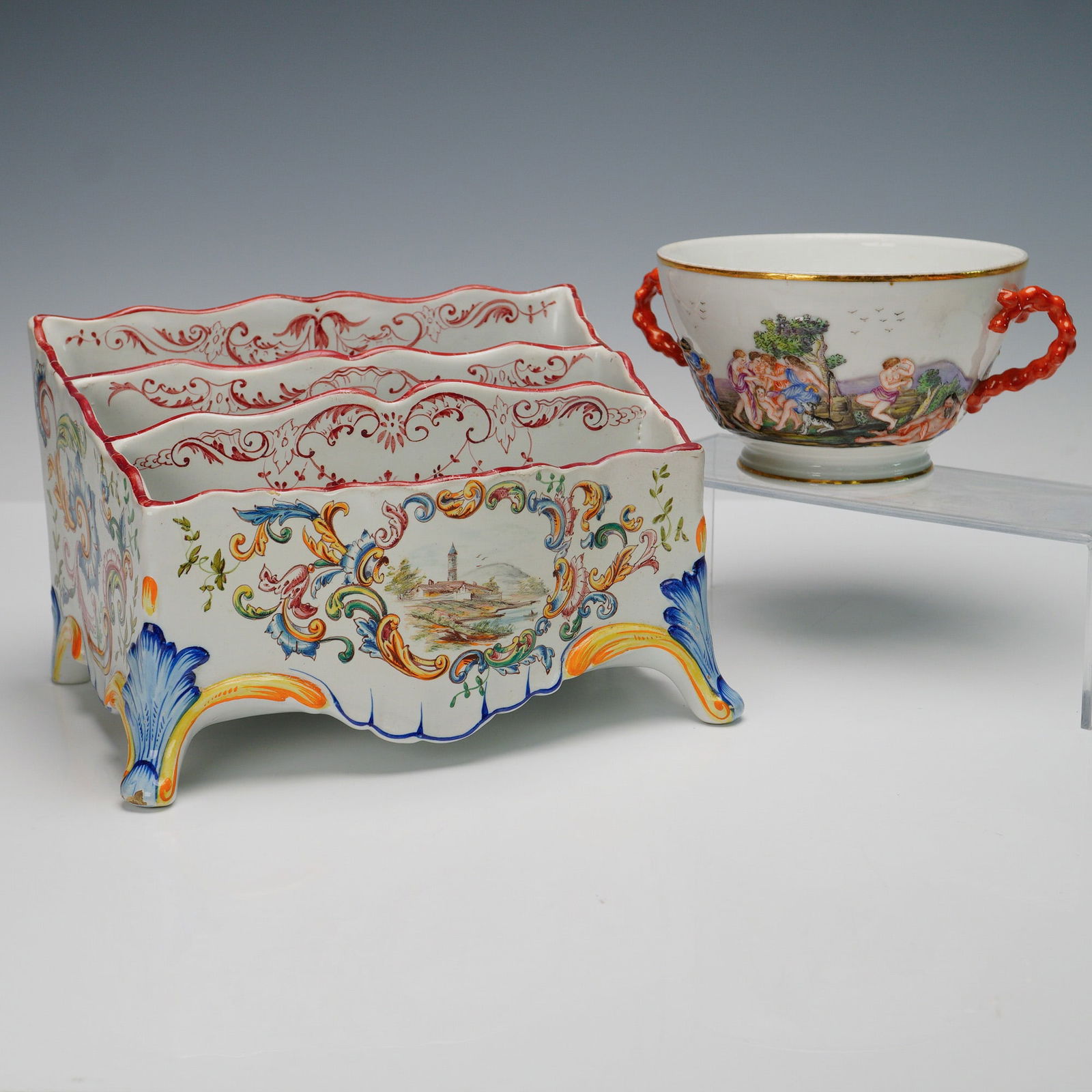 Capodimonte Hand Painted Loving Cup and Art Pottery Letter Organizer: The Capodimonte loving cup shows vivid figural scenes with coral red handles and gilt trim, finely painted in rich colors. Paired with it is a continental letter organizer decorated with scrolling flo