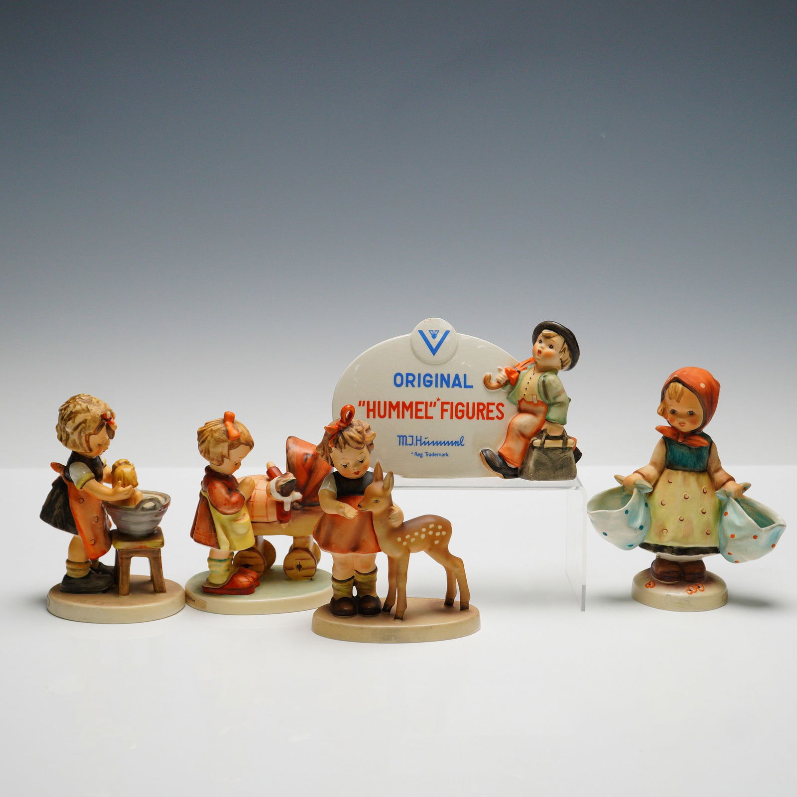 5pc Goebel Hummel Figurines and Plaque: Collection includes four figurines consisting of "Doll Bath" (HUM319) depicting a child washing a doll, "Doll Mother" (HUM57) showing a child with a doll carriage, "Mother's Darling" (HUM175) featurin