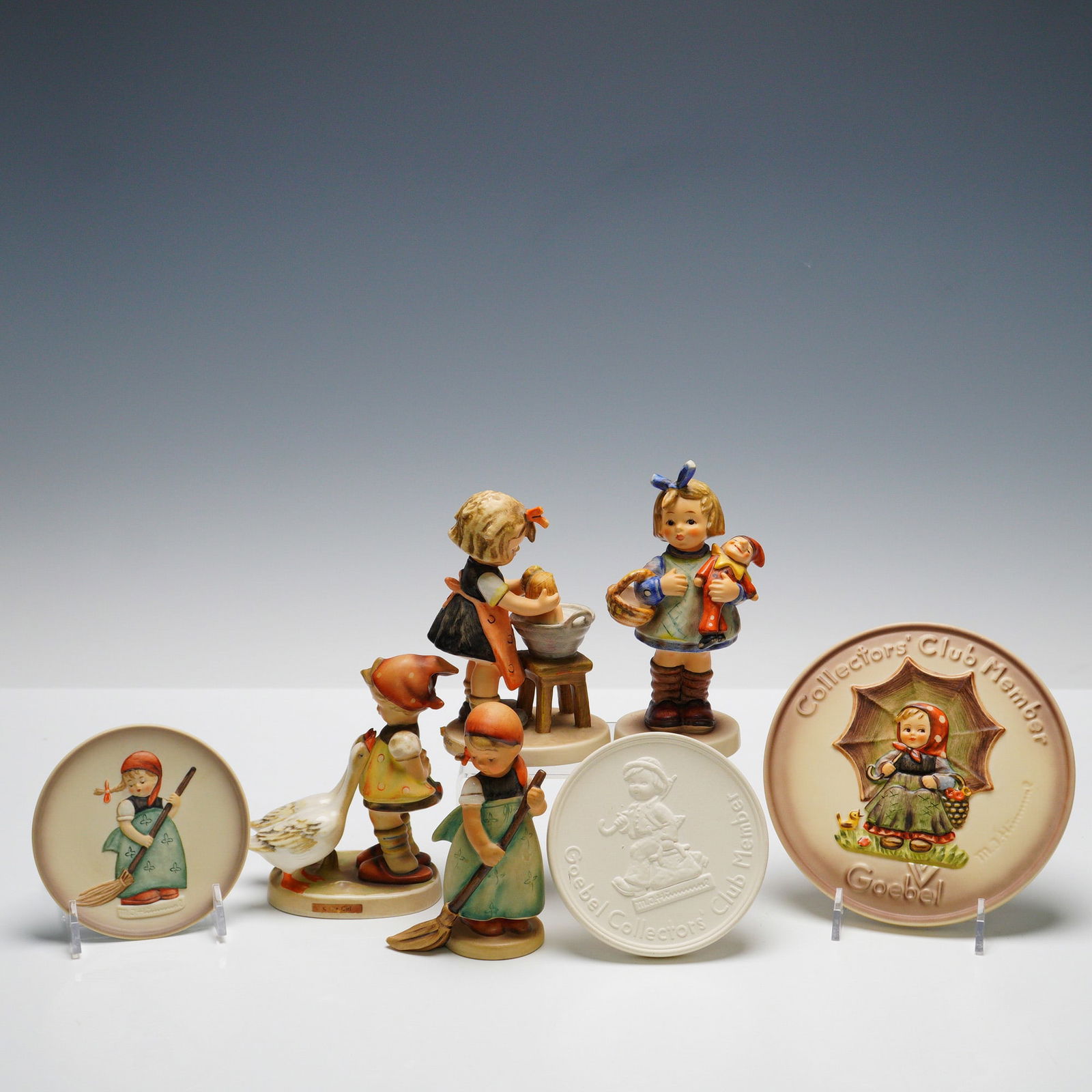 7pc Goebel Hummel Figurines and Plaques: Collection including four figurines and three round plaques. Figurines consist of "Little Sweeper," 'What Now?" (HUM422) exclusive special edition No. 7 produced for members of the Goebel Collectors'