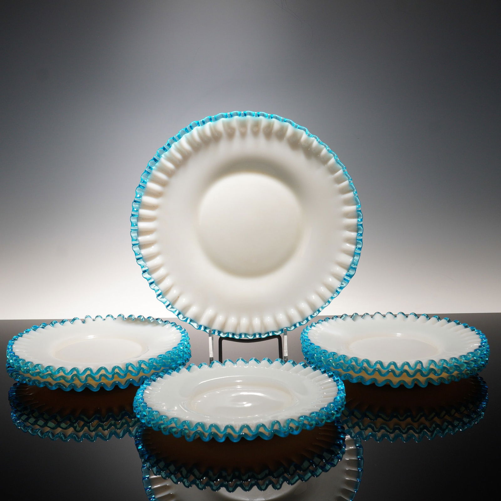 9pc Fenton Aqua Crest Glass Dinner Plates and Charger: A set of eight Fenton Aqua Crest dinner plates with opalescent white glass and ruffled aqua blue trim, paired with a larger charger plate in the same pattern. The coordinated pieces show the bold colo