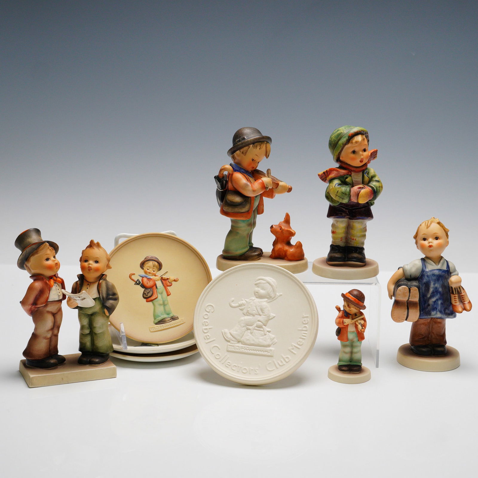 9pc Goebel Hummel Figurines and Plaques: This collection includes five figurines: "Puppy Love" (HUM1), "It's Cold" (HUM421), issued as Exclusive Special Edition No. 6 for members of the Goebel Collectors' Club, "Boots" (HUM14 3/0), "Duet" (H