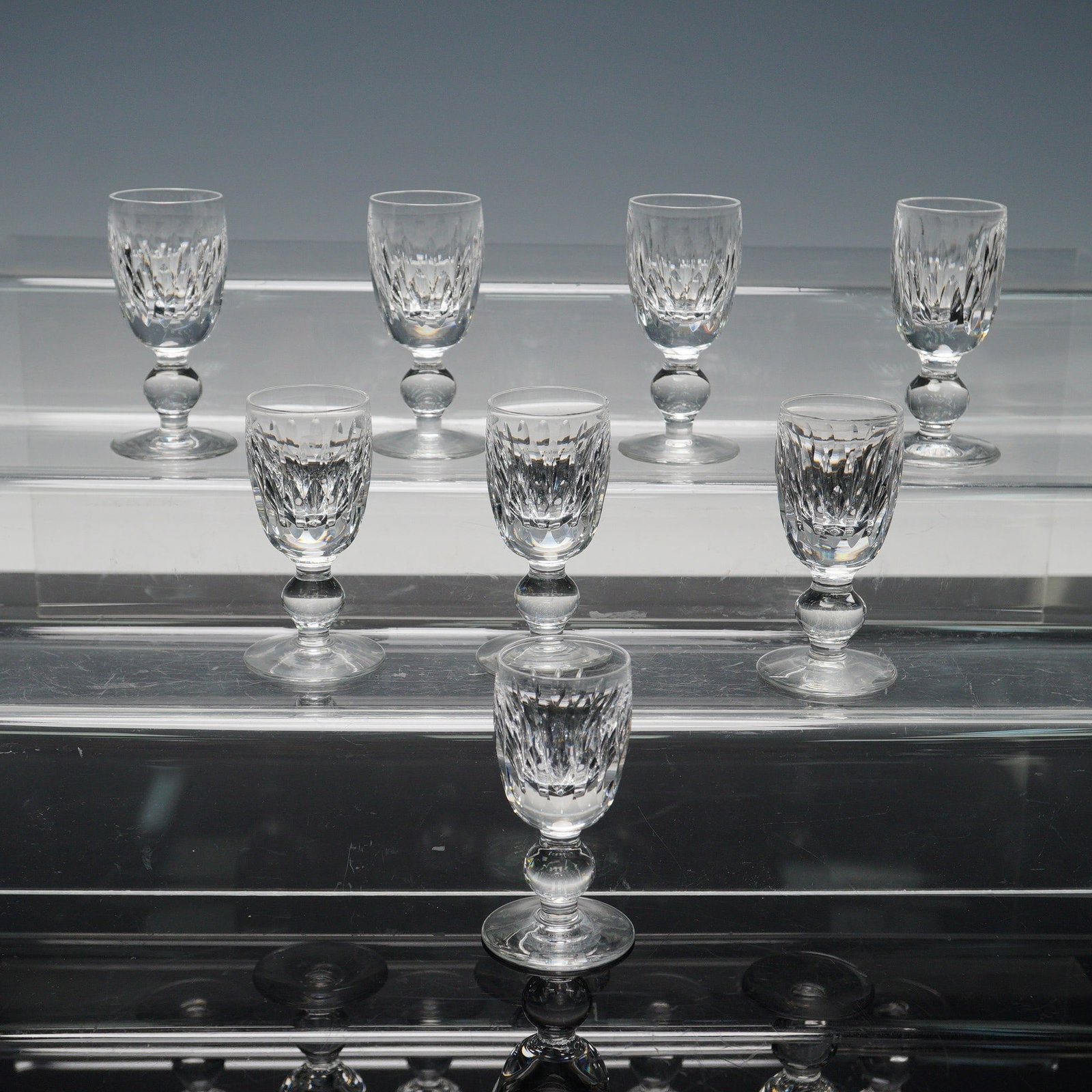 8pc Waterford Maureen Crystal Cordial Glasses: Set of Waterford Maureen crystal cordial glasses featuring a classic tulip-shaped bowl with vertical cuts, a faceted stem, and a round foot. This pattern highlights the fine craftsmanship and clarity 