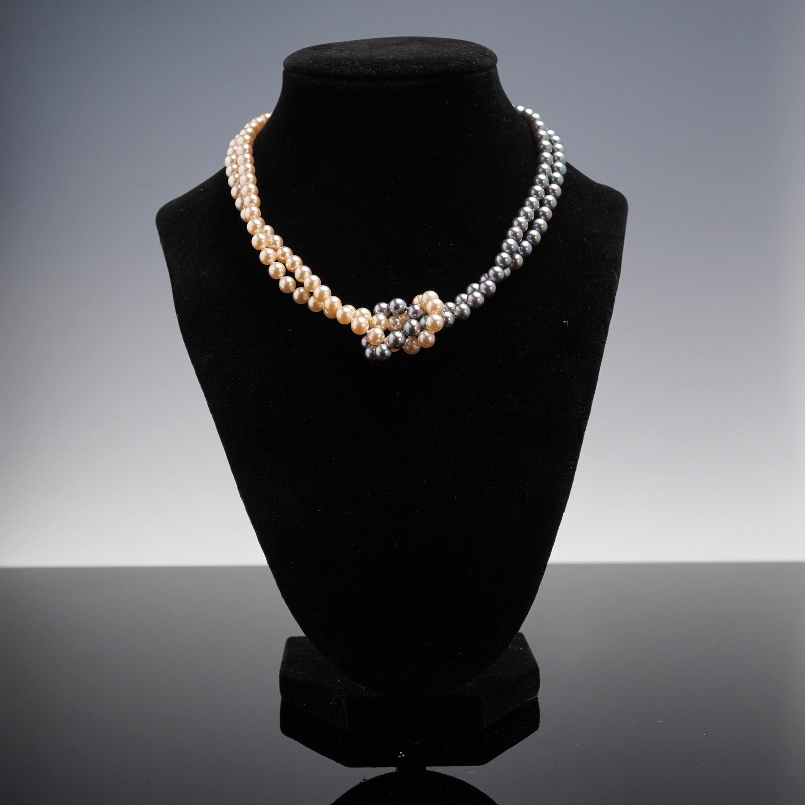 Majorica Simulated Pearl & Sterling Silver Two-Tone Double Strand Necklace: Offered here is a beautiful Majorica simulated pearl necklace, showcasing two strands of hand-knotted pearls in warm cream and rich gray tones. The strands meet at the front with a distinctive twisted
