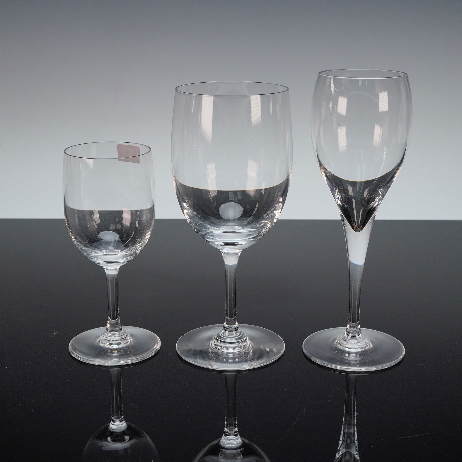 2pc Baccarat Avignon Water Goblet & Chateau Red Wine Glasses: The Avignon goblet is crafted in clear crystal with a cylindrical bowl and a faceted, knobbed stem leading to a circular foot. The Chateau red wine glass features a tall, elegant stem and a wide, flar