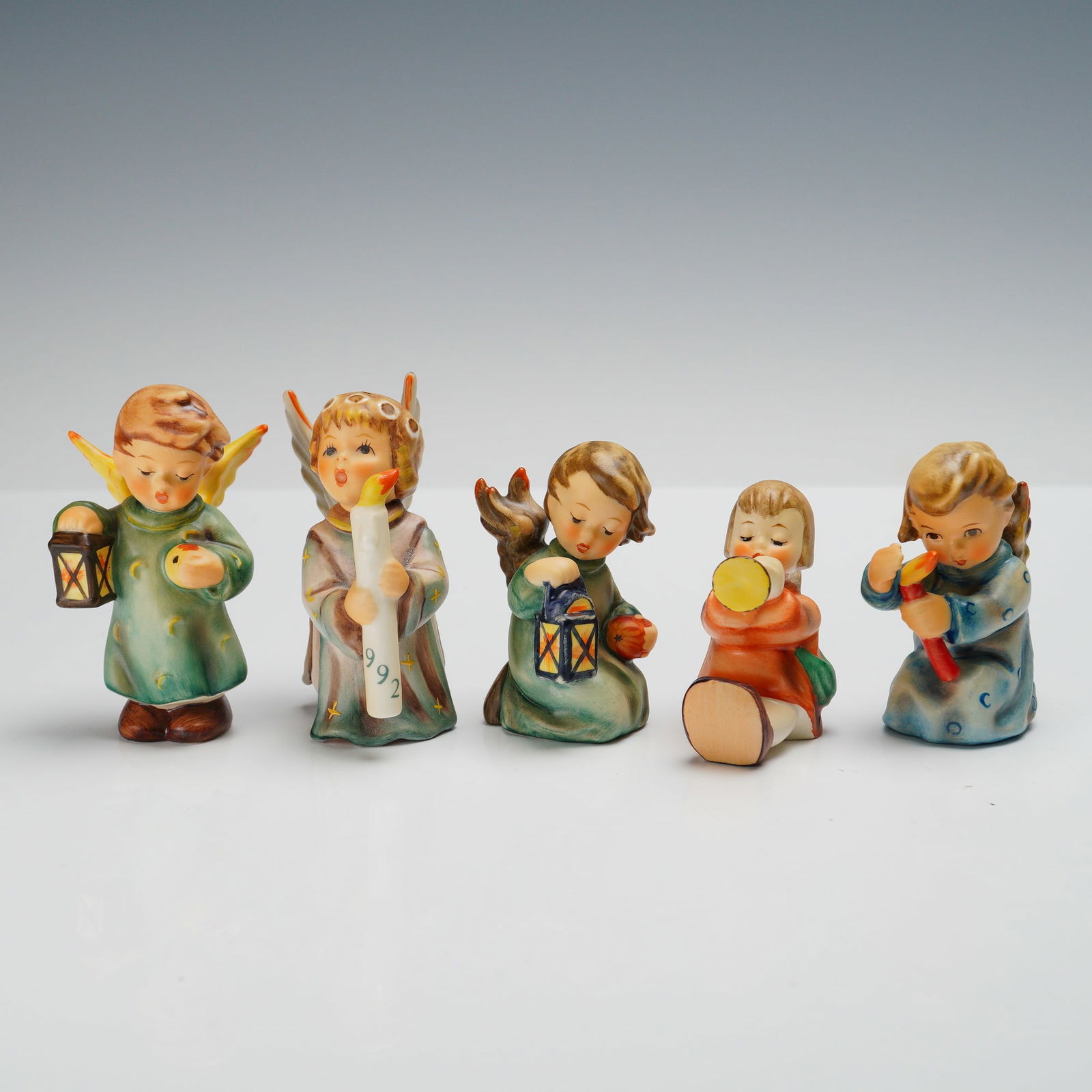 5pc Goebel Hummel Angel Figurines, Guiding Angel, Joyous News, and More: Five porcelain angel figurines, including Good Night (214), Angel Light Up the Night (622), Guiding Angel (357), Joyous News (2121), and Shining Light (358). Each hand-painted porcelain figure depicts