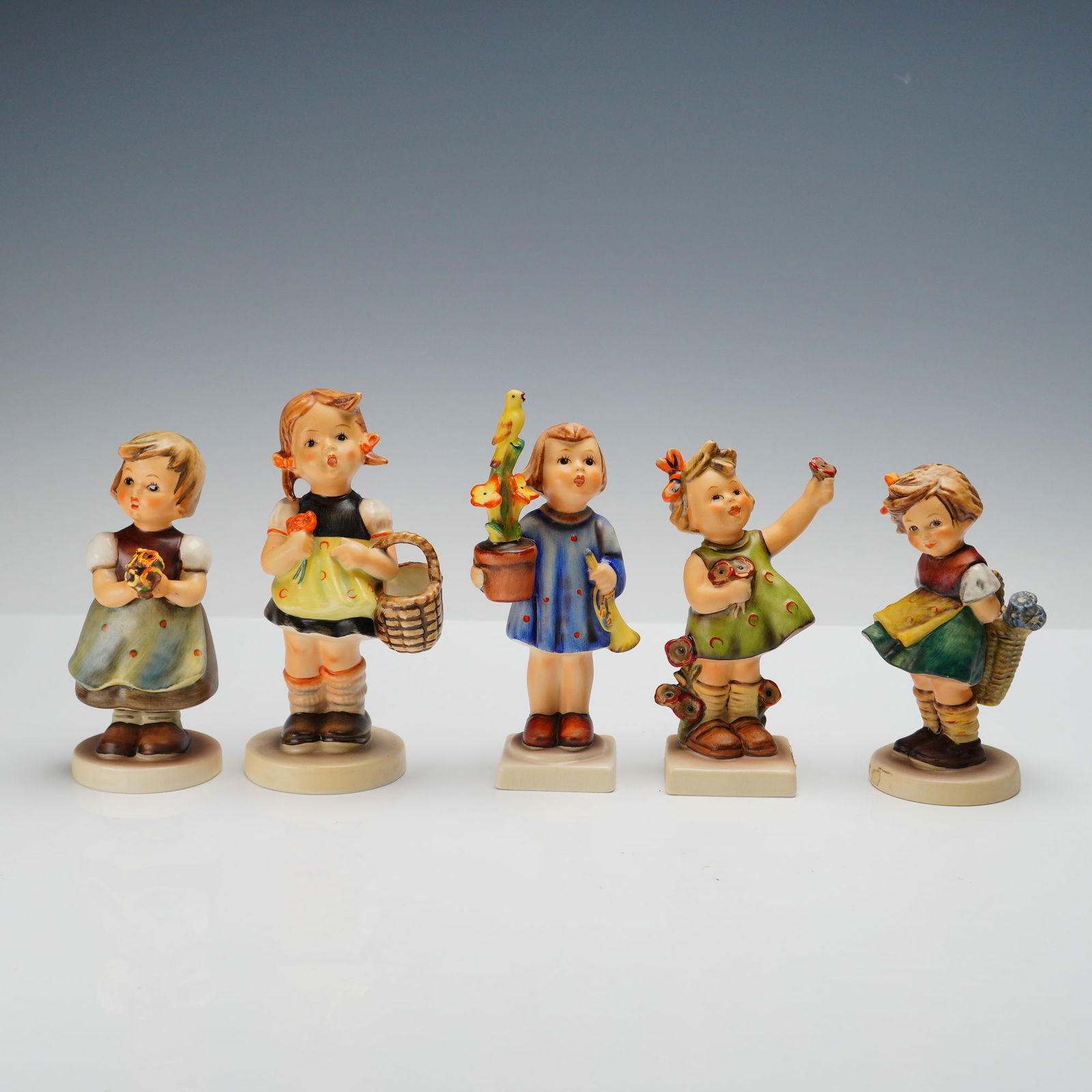 5pc Goebel Hummel Figurines, Spring Flowers: Charming set of five Goebel Hummel porcelain figurines, each celebrating the innocence of childhood with floral and seasonal themes. This grouping includes Bashful (377), Sister (98), Spring Cheer, Co
