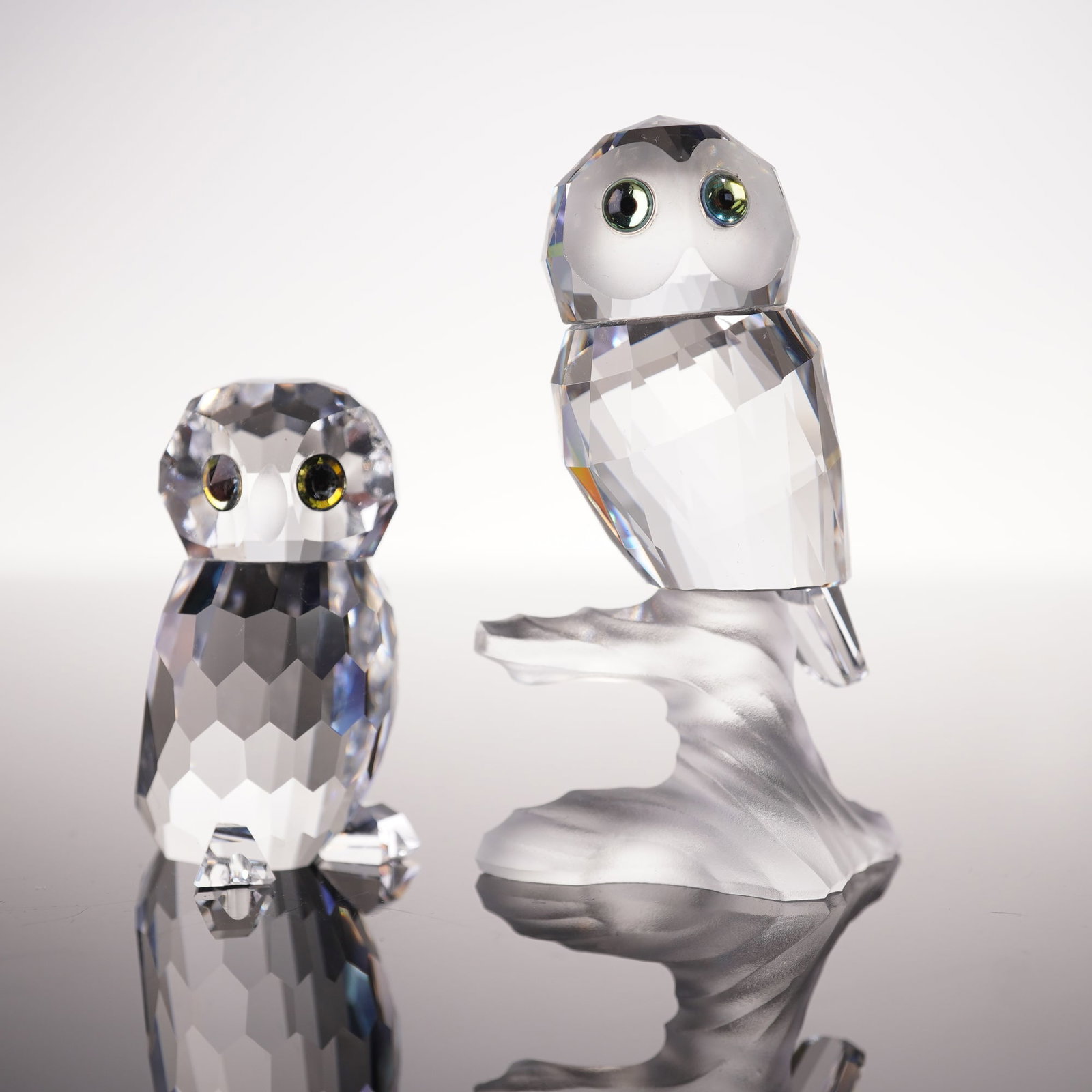 2pc Swarovski Silver Crystal Figurines, Owlet and Owl on Branch: A cute collection of two figurines comprising Owlet 188386 and Owl on Branch 119442. One owl is modeled in a compact upright stance with faceted talons and a rounded form, while the other is perched u
