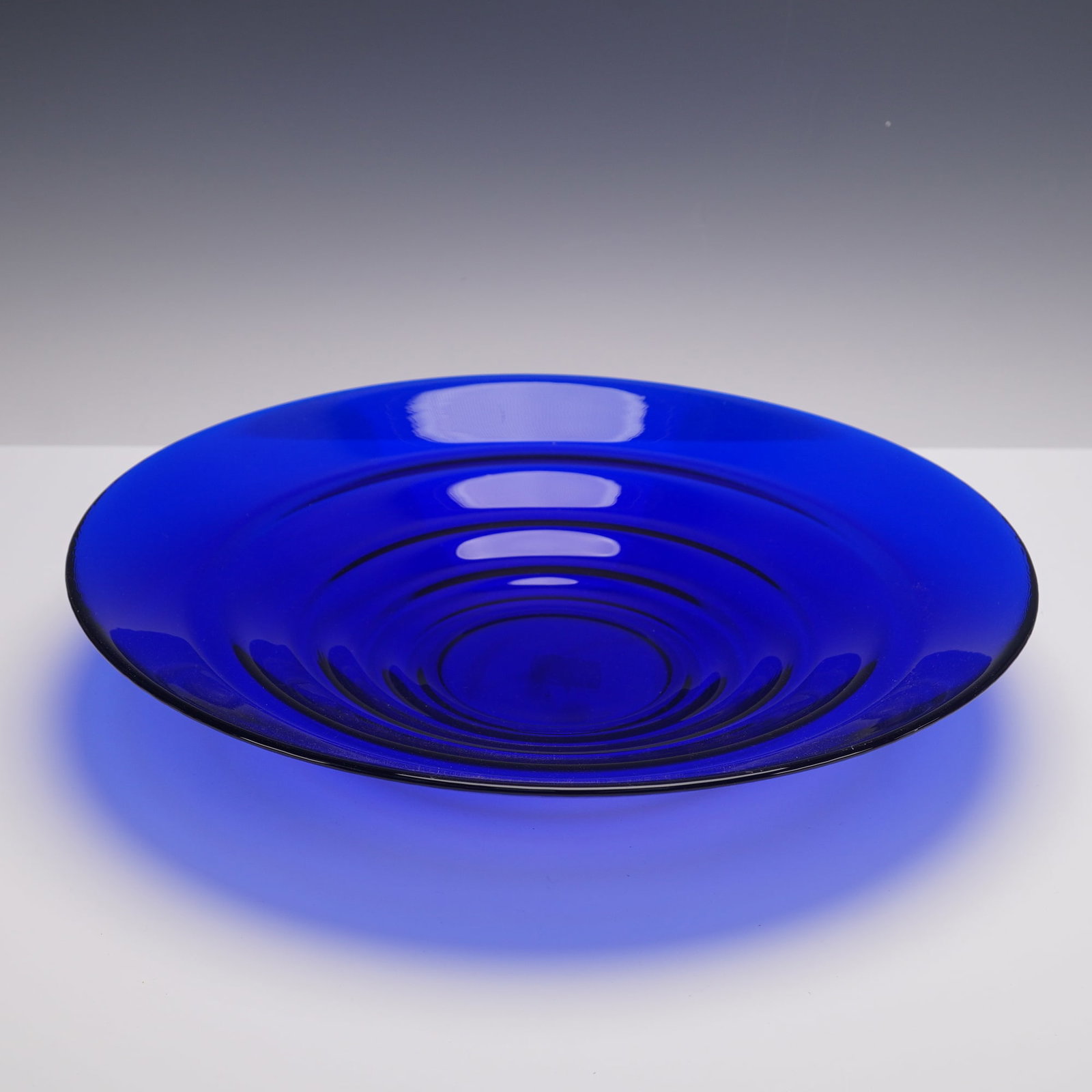 Oversized Cobalt Blue Glass Console-Centerpiece Bowl: Striking oversized cobalt blue glass console or centerpiece bowl featuring a wide, shallow form with concentric circular design. The underside rim is accented with subtle ribbing (not visible in photo