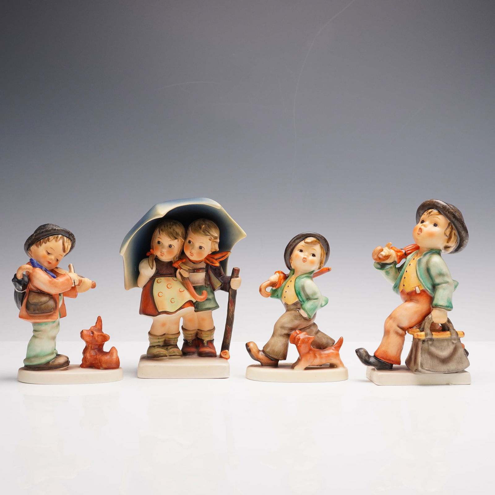 4pc Goebel Hummel Figurines, Rainy Day: Charming collection of four classic Goebel Hummel figurines. Includes Merry Wanderer 7/0, the iconic traveler with umbrella and satchel; Strolling Along 5, featuring a jaunty boy with his walking stic