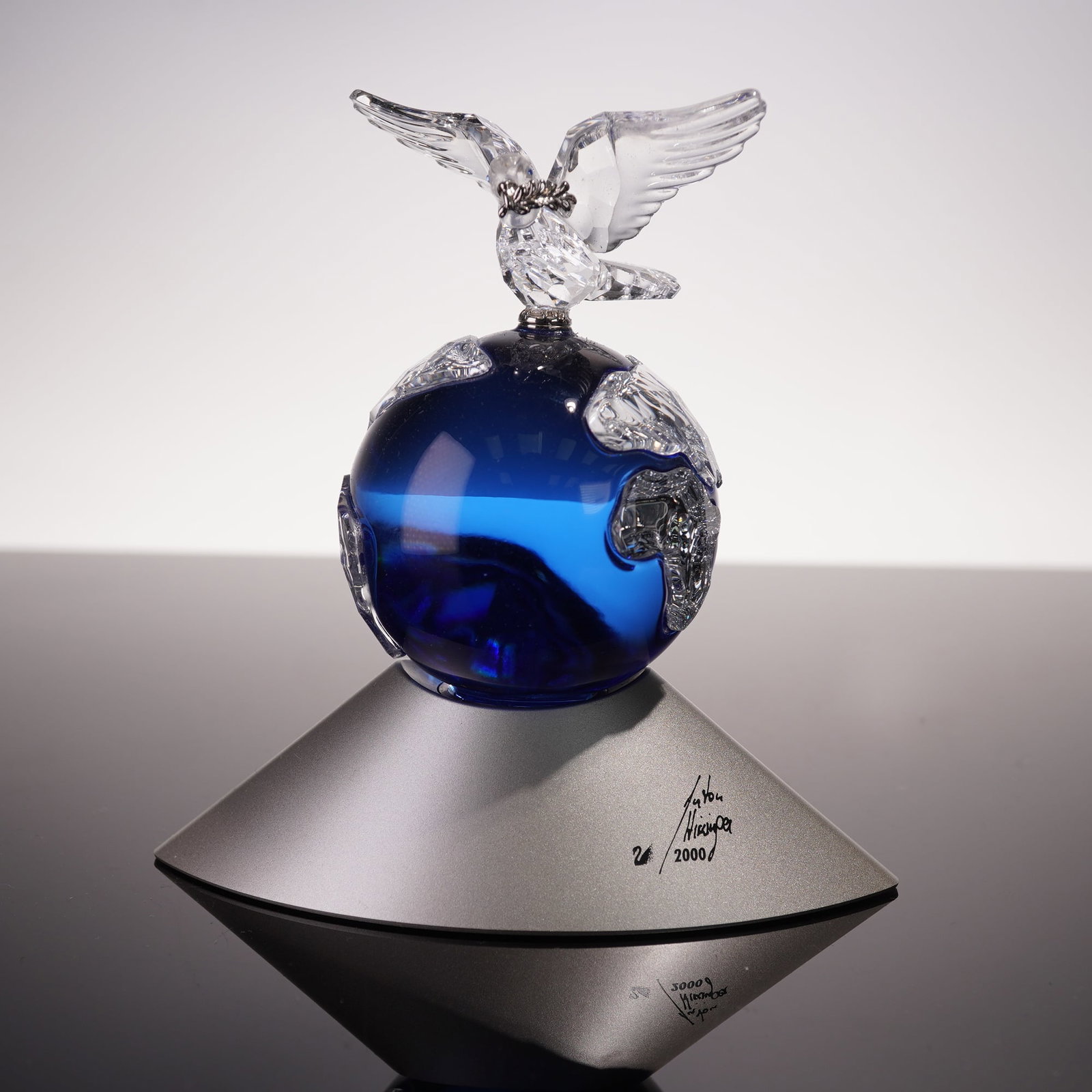 Swarovski Crystal Figurine, Planet Millennium Edition 2000 With Box: Swarovski Crystal Planet Millennium Edition 2000, created to commemorate the new millennium. The design features a deep blue globe with faceted clear crystal continents and a clear crystal dove holdin