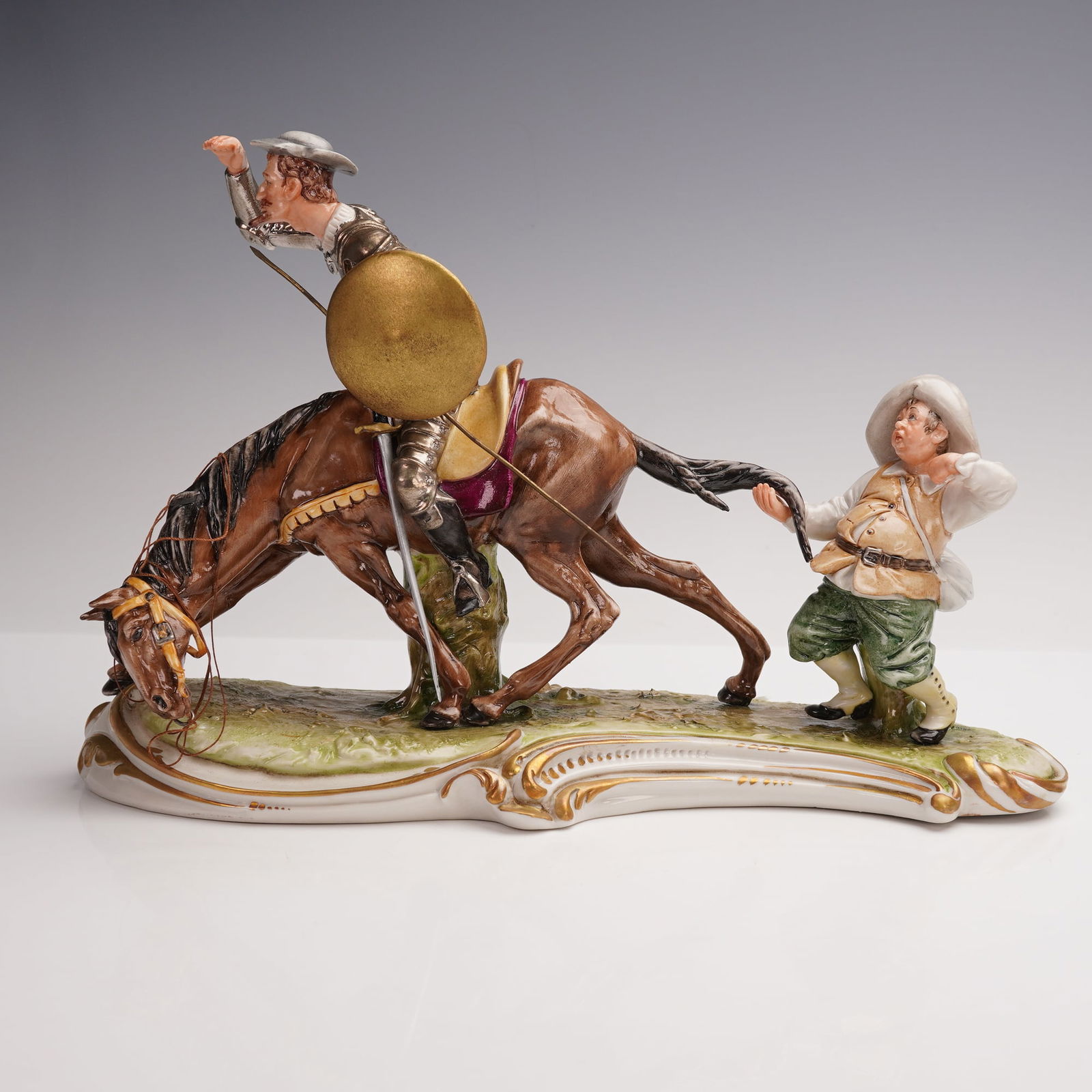 King Capodimonte Figurine, Don Quixote & Sancho Panza: Don Quixote on horseback with his loyal companion Sancho Panza at his side. This finely detailed porcelain piece captures Don Quixote in armor, holding a shield and peering ahead, while his horse bows