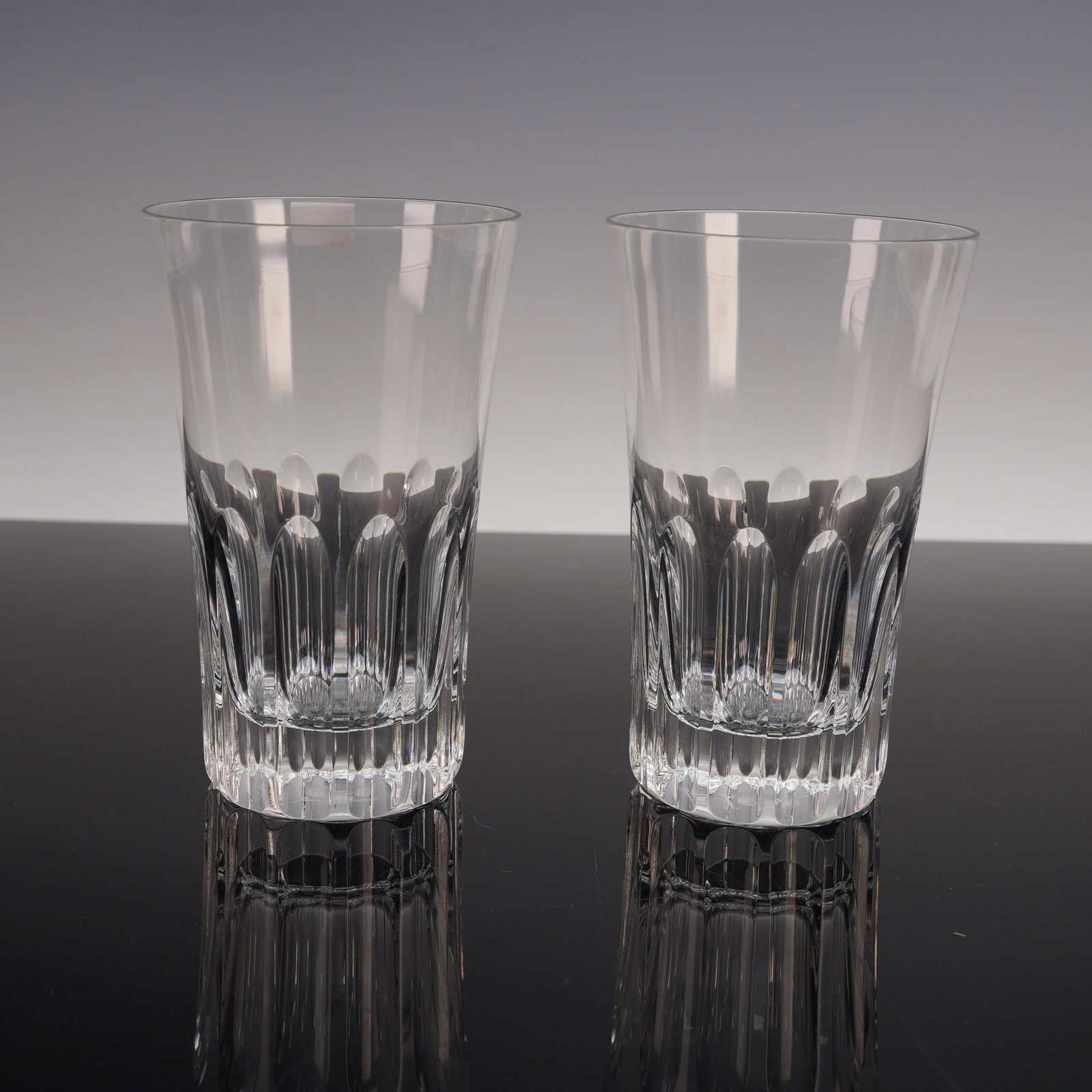 2pc Baccarat Crystal Highball Glasses, Etna Pattern: This pair of Baccarat glassware features the striking Etna pattern, known for its bold and dynamic design. The glasses have a robust, clear crystal construction with fluted detailing that cascades dow