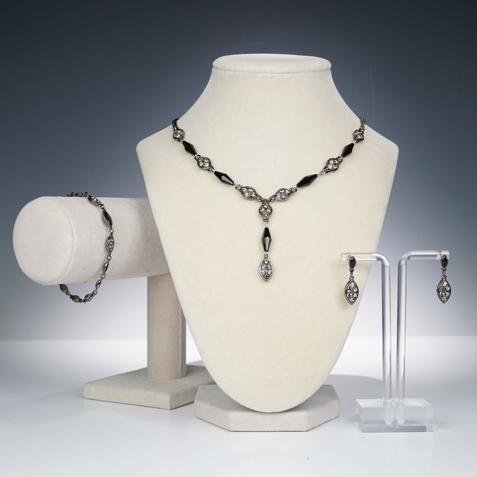 4pc Swarovski Crystal Necklace, Bracelet, and Earrings Set: A stylish four-piece Swarovski crystal jewelry set including a necklace, bracelet, and earrings. Each piece features marquise-shaped links accented with clear Swarovski crystals and faceted black crys