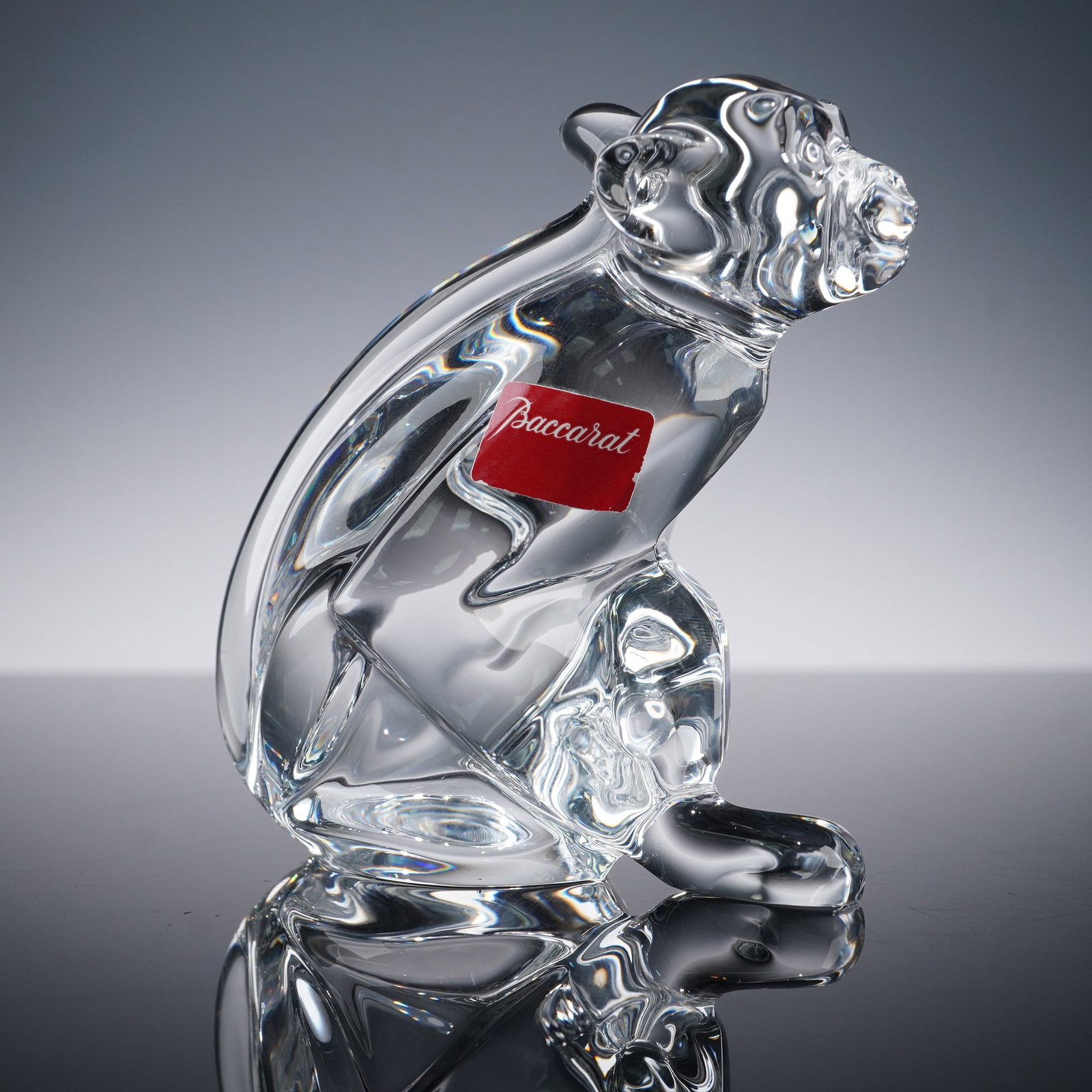 Baccarat Crystal Figurine, Zodiac Monkey: One of a kind crystal figurine depicting a seated monkey, meticulously detailed with smooth contours and delicacy. Baccarat sticker label. Baccarat backstamp. Issued: 2004 Dimensions: 3.25"L x 2"W x 3