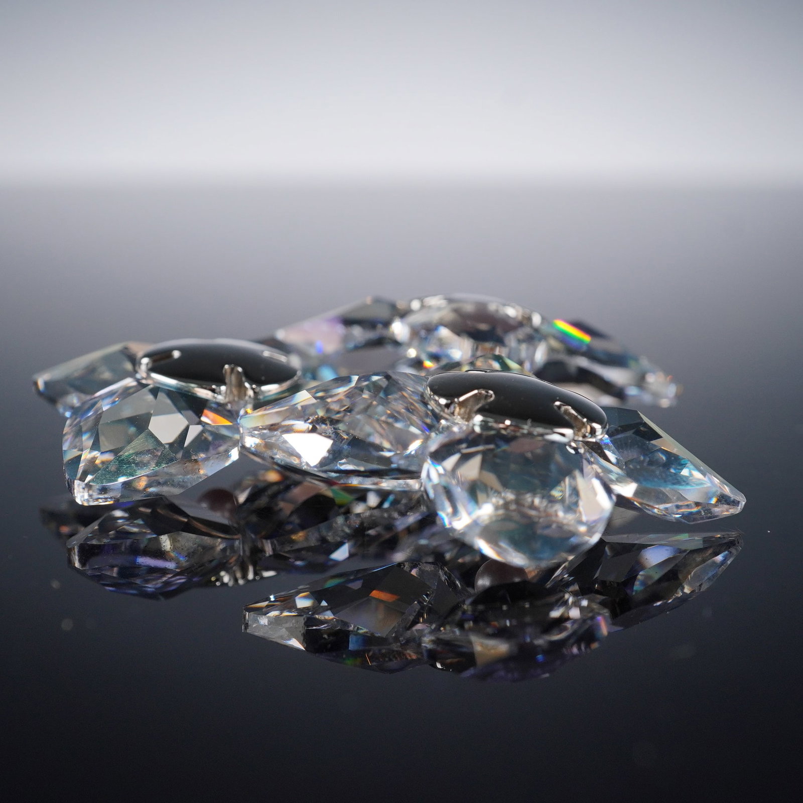 Swarovski Crystal Paradise Flowers Figurine, Dribella Crystal Moonlight: Part of the Exotic Flowers collection. The piece is crafted with clear faceted crystal petals accented by rosaline pearl centers, forming stylized floral motifs. Each element is precisely cut to refle