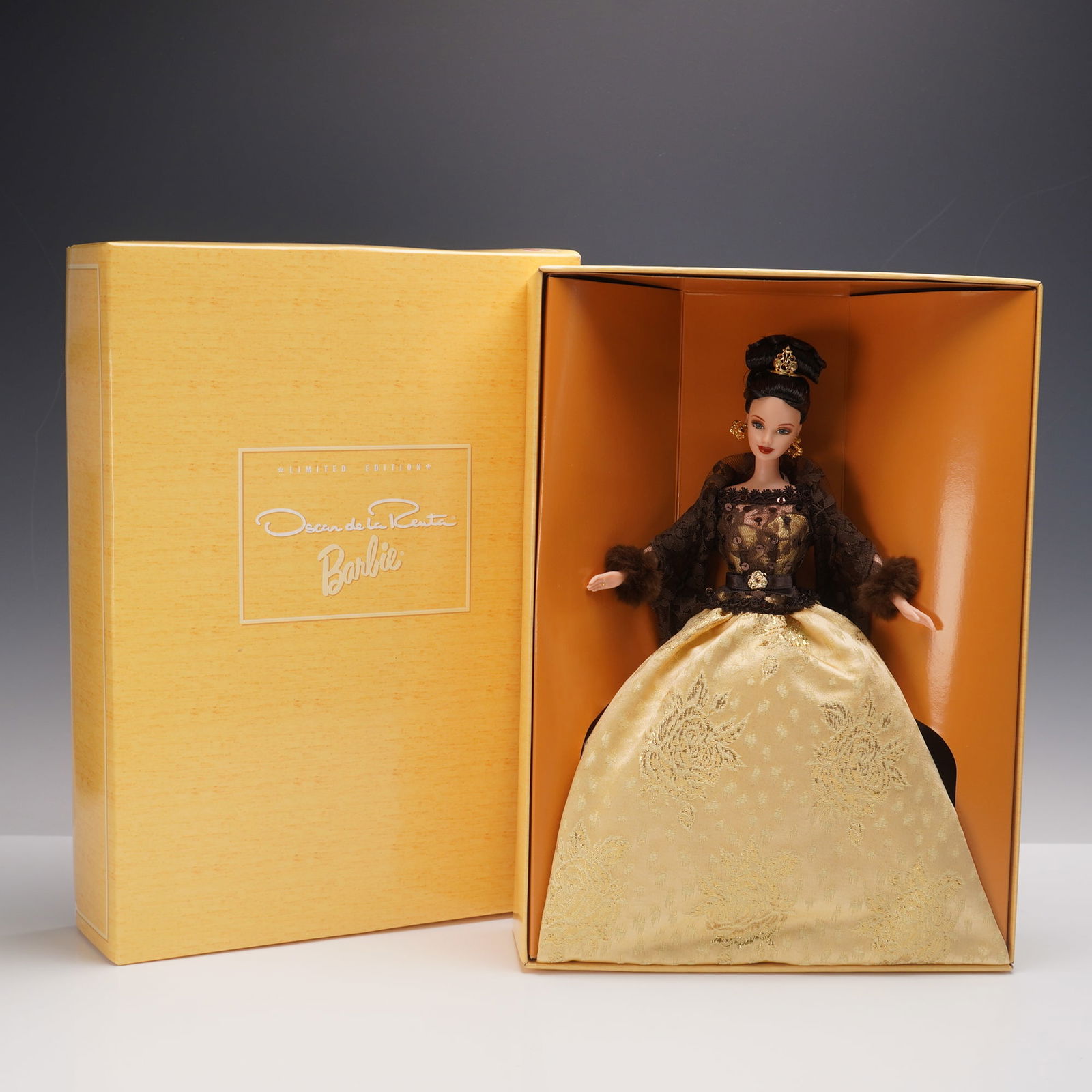 Oscar de la Renta Limited Edition Barbie Doll 20376 w/ Stand & COA: This exquisite limited edition Barbie doll is a collaboration between Mattel and legendary fashion designer Oscar de la Renta. Dressed in a luxurious golden brocade gown with intricate floral detailin