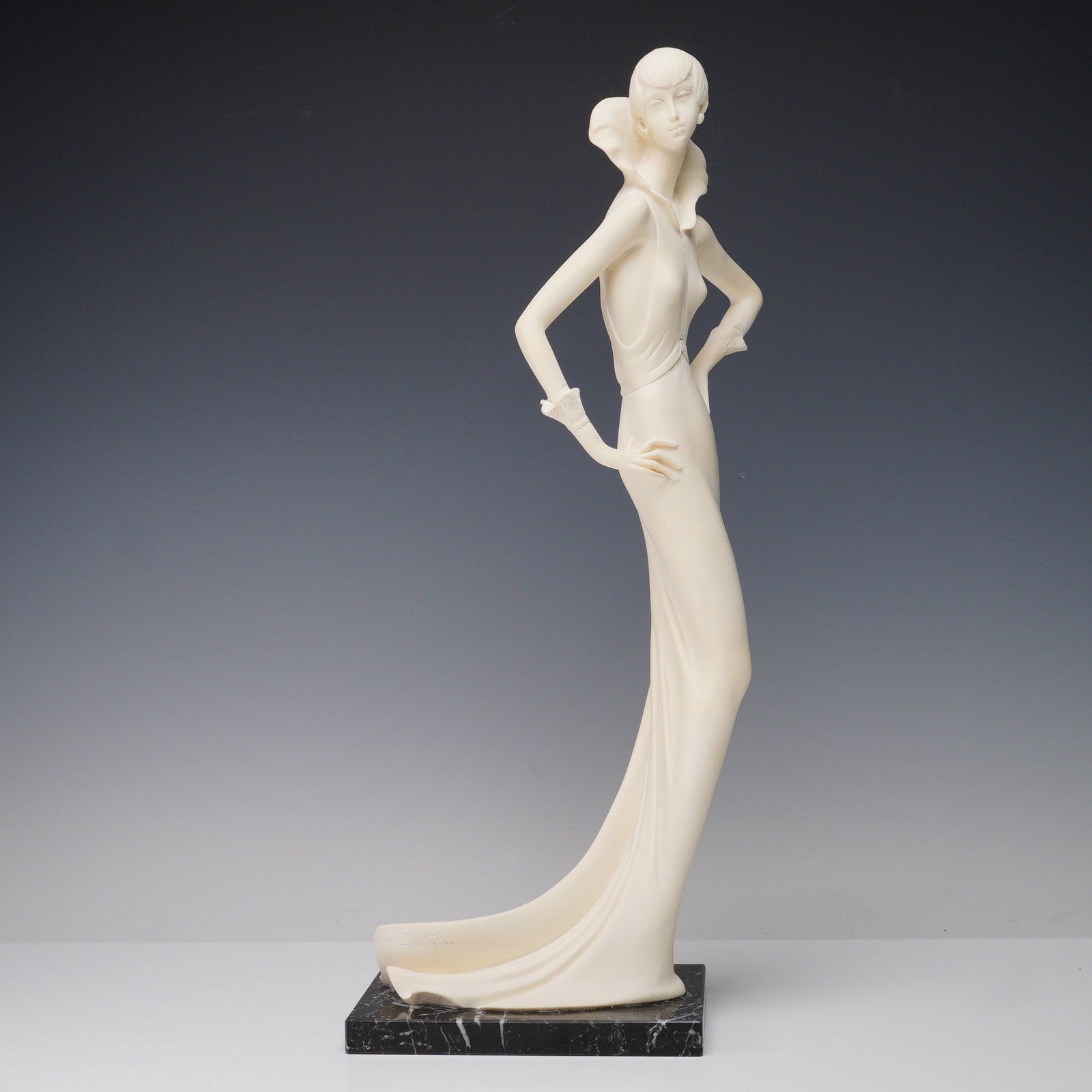 Amilcare Santini Art Deco Flapper Sculpture: Elegant sculpture depicting a tall, elongated female figure in a sleek floor-length gown with exaggerated collar and delicate wrist details. The figure is posed with hands on hips, exuding the stylize