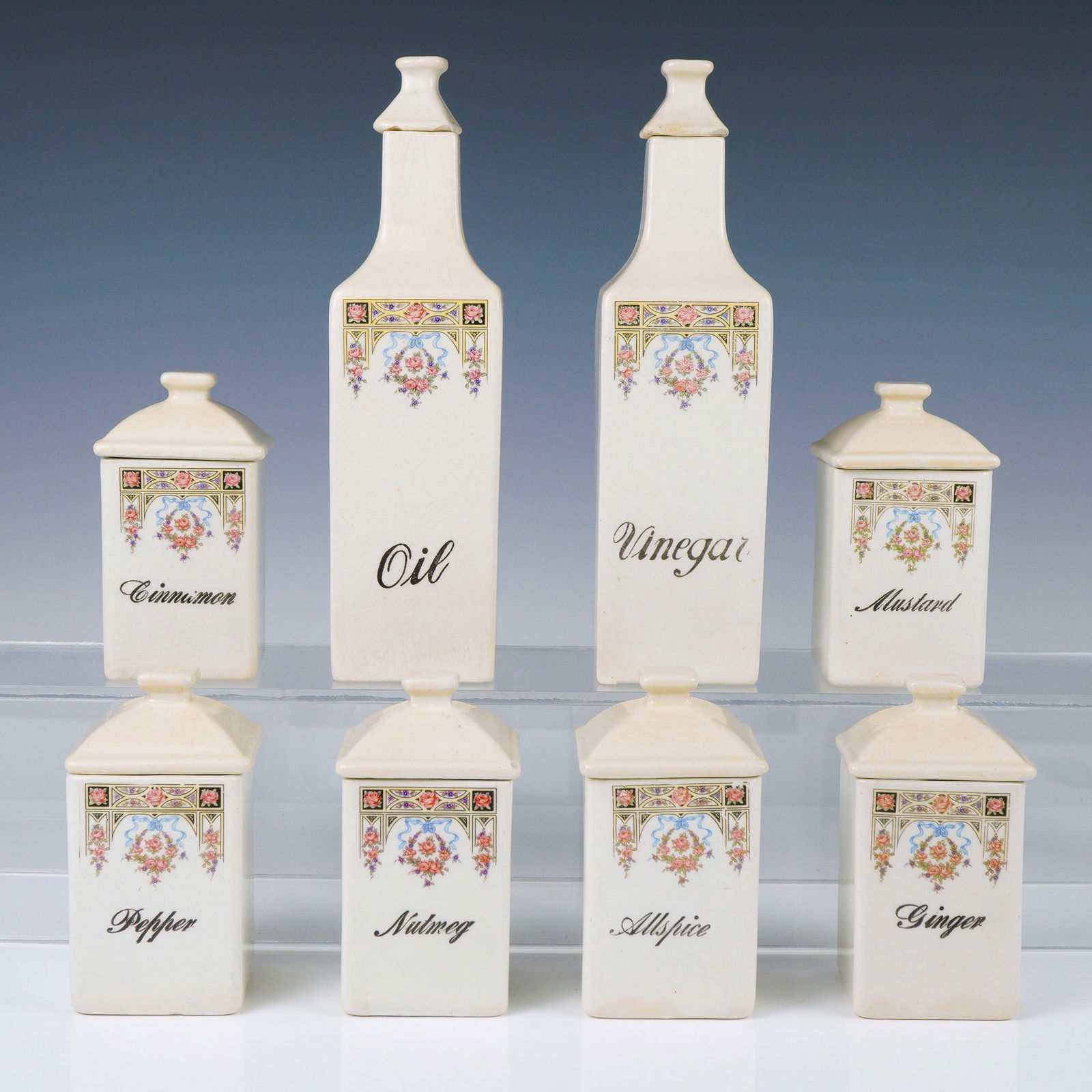 Ceramic Kitchen Canisters, Floral Motif Spice and Condiment Set: A charming and complete set of eight antique ceramic kitchen canisters, each beautifully adorned with vibrant floral transfer designs and classic black script labels. This late 19th to early 20th-cent