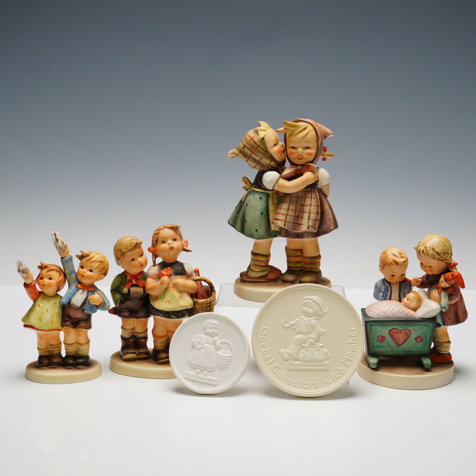 6pc Goebel Hummel Figurines and Plaques: Collection includes four figures: "Auf Wiedersehen" (HUM153/0) depicting two children waving, "Blessed Event" (HUM333) featuring children gathered around a cradle, "To Market" (HUM49/0) showing two ch