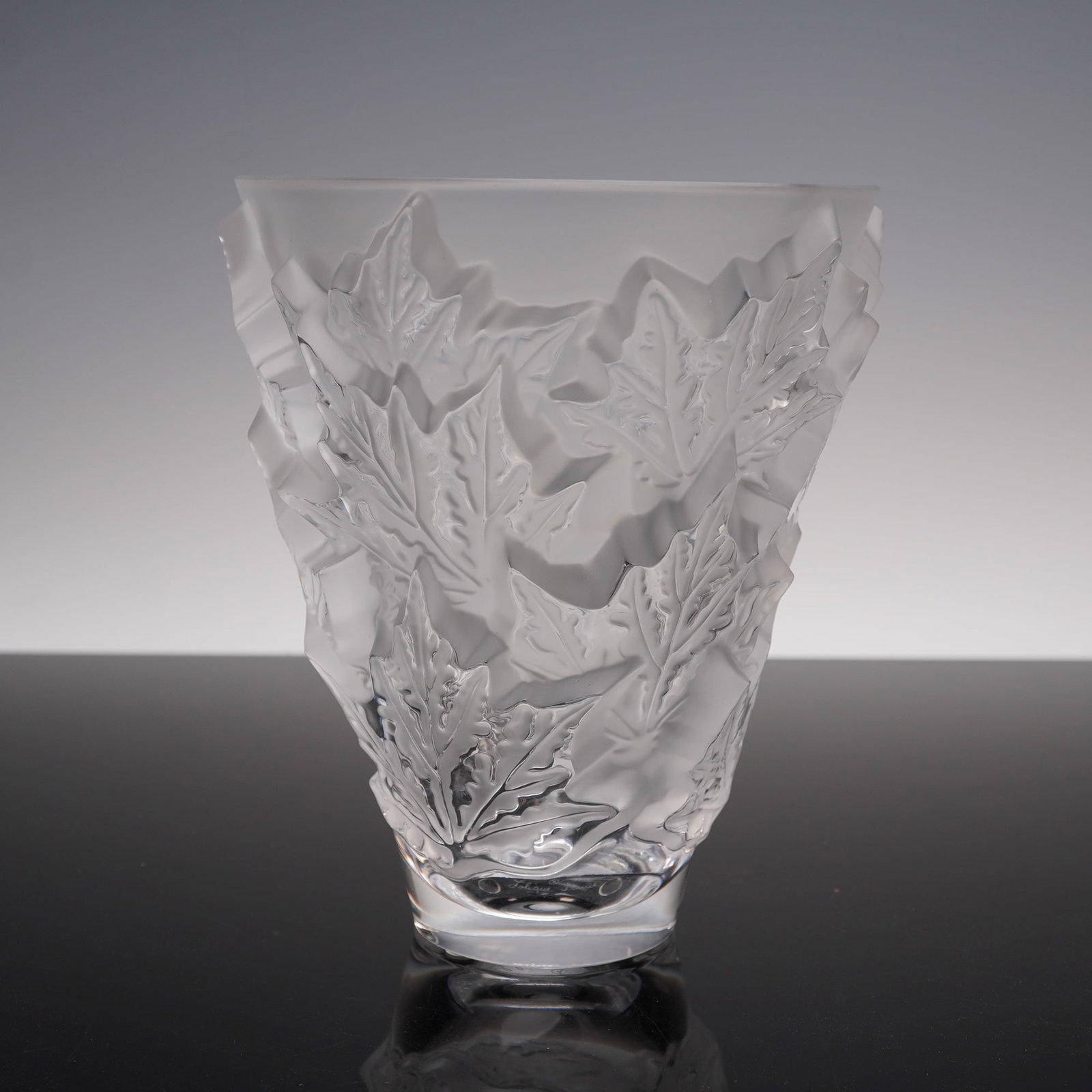 Lalique Crystal Champs Elysees Vase: Offered here is a Lalique crystal vase in the Champs Elysees pattern, inspired by the broad avenues and natural beauty of Paris. The vase features deeply detailed frosted leaves in relief, creating st