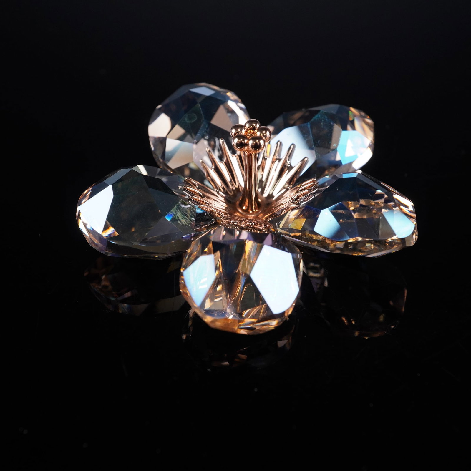 Swarovski Crystal Paradise Flowers Figurine, Diona Silk Moonlight: Crafted from faceted moonlight crystal in the form of a five-petaled blossom with a gold-plated metal pistil at the center. The underside is marked with the Swarovski swan logo. The figurine is presen