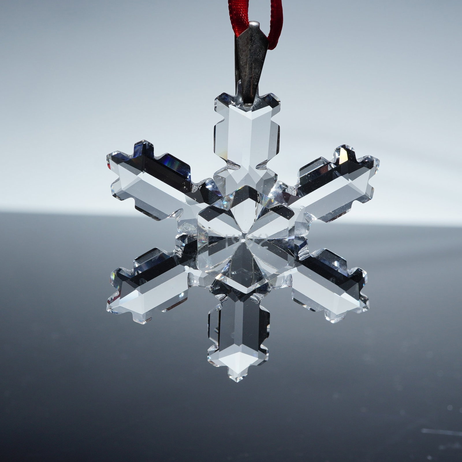 Swarovski Crystal Holiday Ornament, 1992 Annual Edition Snowflake: Swarovski crystal holiday ornament, 1992 annual edition snowflake 168690, featuring a six-pointed clear crystal design with precision-cut facets that beautifully refract light. The ornament is suspend