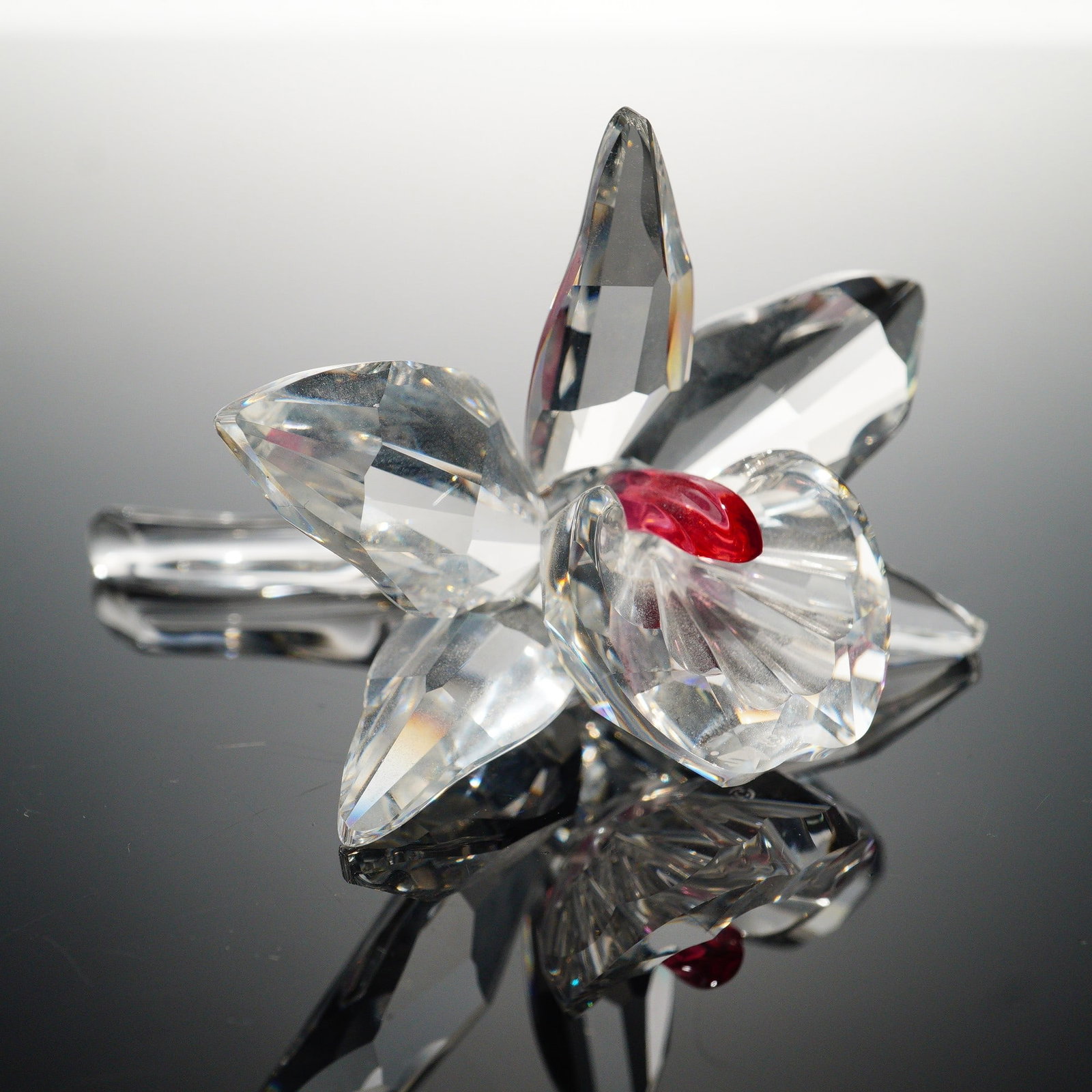 Swarovski Crystal Figurine, Pink Centre Orchid: Swarovski offers this graceful Pink Light Centre Orchid from the Exquisite Accents theme group. The flower is crafted in faceted clear crystal, its petals radiating with brilliance, while the vibrant 