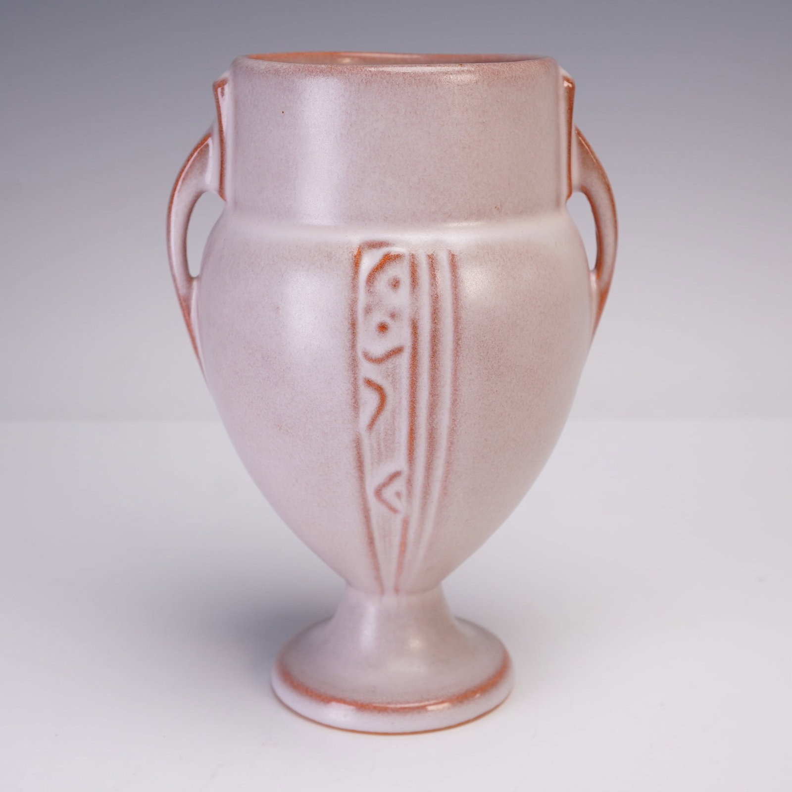 Roseville Pottery White Double-Handle Vase, Moderne: Roseville Pottery Moderne vase in a white glaze with subtle pink undertones, featuring a double-handle design. The vase is decorated with vertical raised panels incorporating stylized Art Deco motifs 
