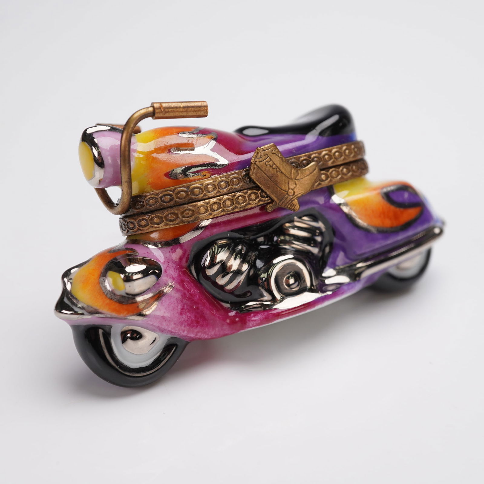 Chanille Limoges France Motorcycle Treasure Box: Hand-painted porcelain hinged treasure box crafted in the shape of a motorcycle, decorated with a vibrant multicolor enamel finish in shades of orange, yellow, pink, purple, and black with flame motif