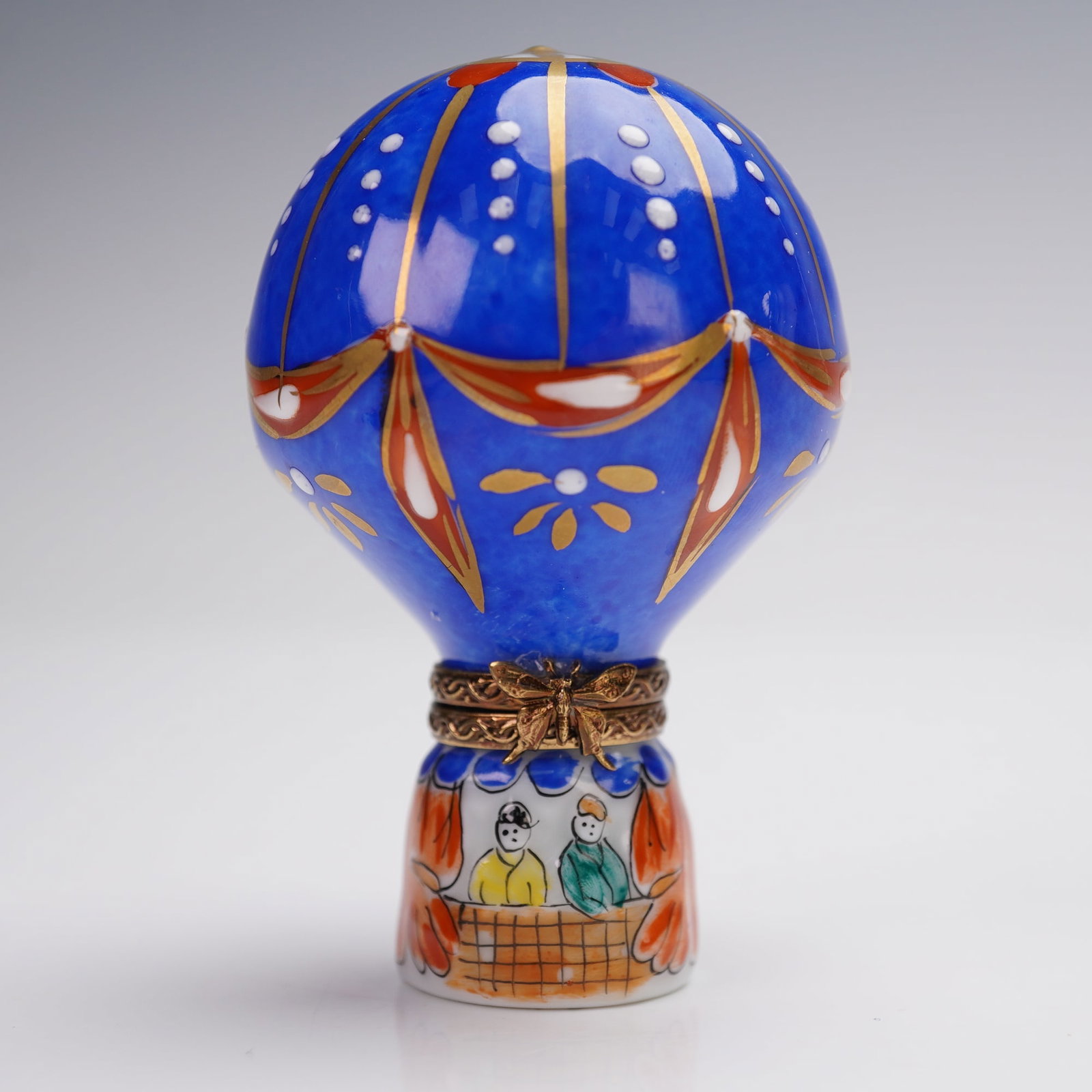 Rochard Limoges Porcelain Treasure Box, Hot Air Balloon: This exquisite porcelain treasure box is modeled as a hot air balloon with intricate hand-painted decorations. The balloon features vibrant blues, gold accents, and delicate floral details, while the 