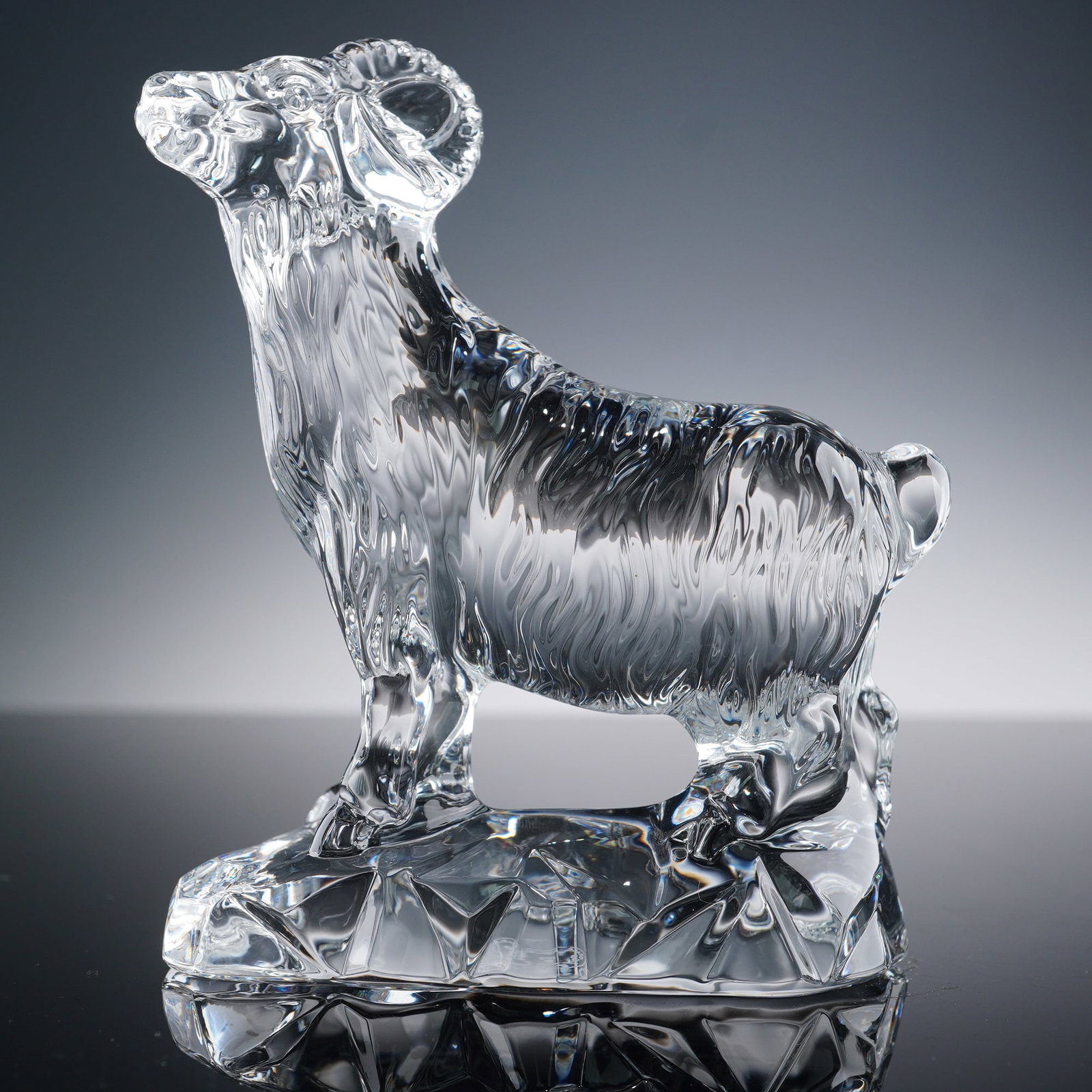 Baccarat Crystal Chinese Zodiac Animal Figurine, Ram: Baccarat crystal Chinese Zodiac figurine, Ram, featuring a clear crystal body with finely detailed fur texture and gracefully curved horns. The ram stands on a faceted crystal base, symbolizing streng