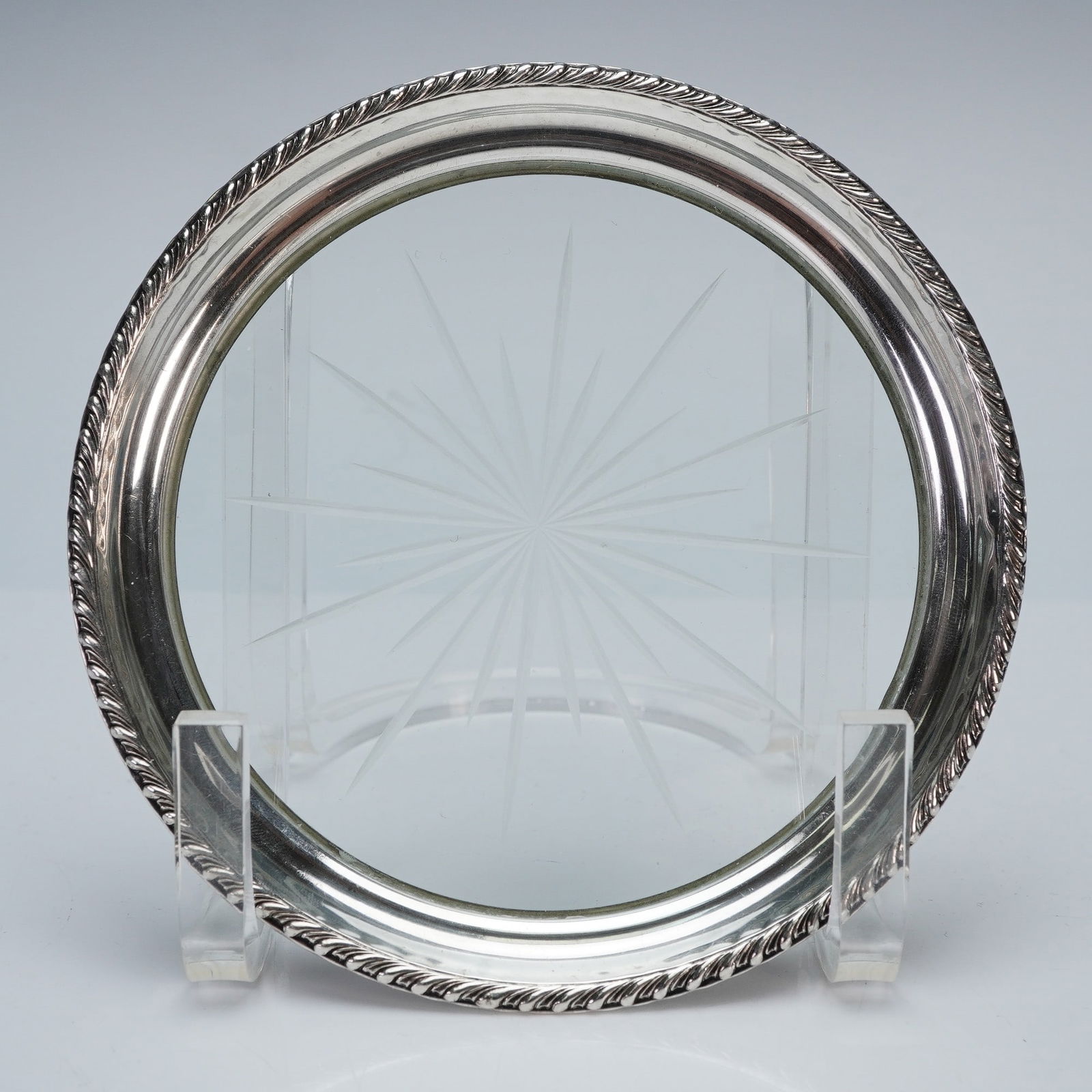 2pc Webster & Frankln M. Whiting Sterling Silver and Glass Wine Coasters: A classical set of two sterling and glass wine coasters. Each coaster showcases a circular glass base intricately cut with a starburst motif and the sterling silver is decorated with beaded and rope p