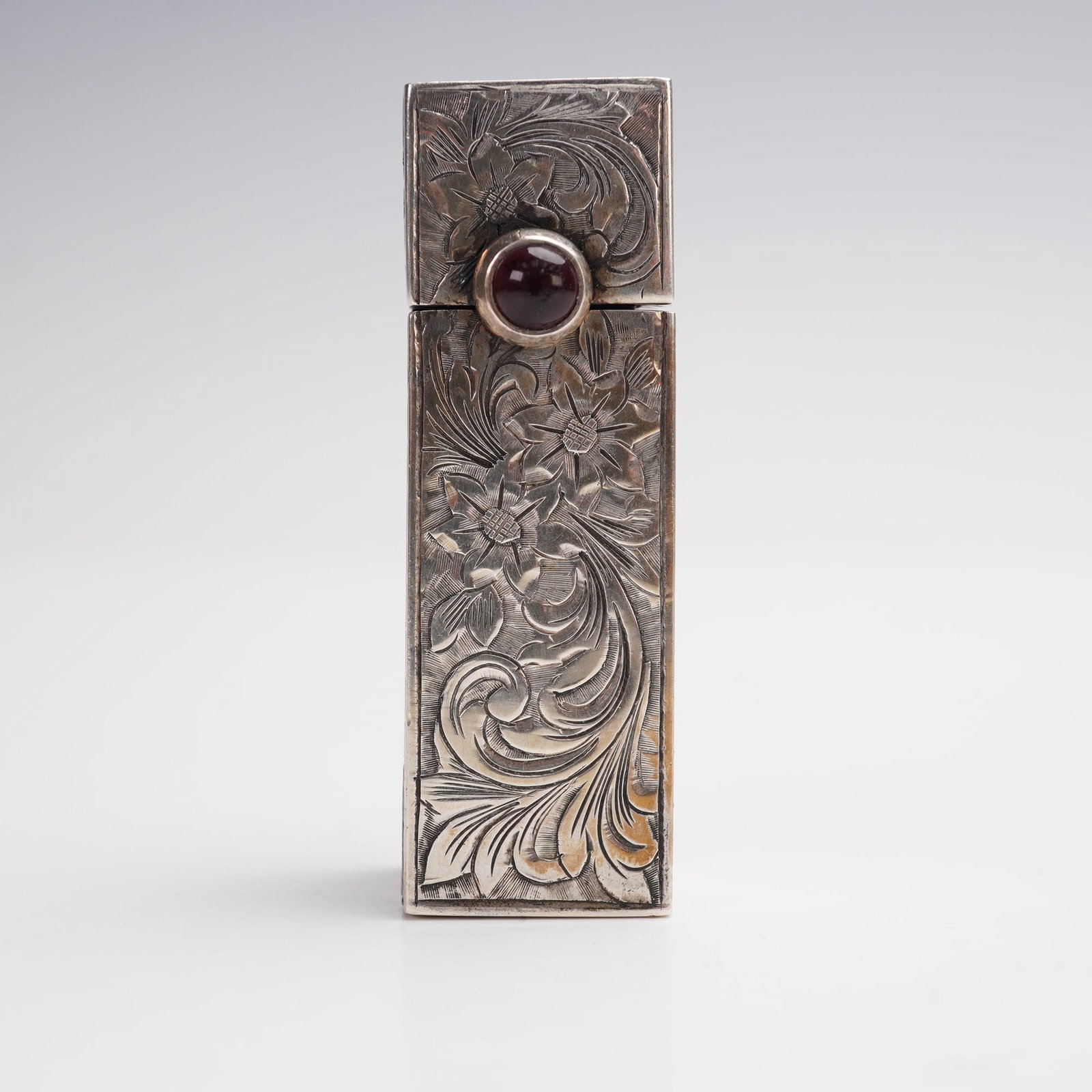 800 Silver Etched Floral Lipstick Case: Art Deco-style floral lipstick case with hinged lid, fitted interior mirror, and a faux-amethyst cabochon accent mounted on the exterior. The rectangular form features detailed floral and foliate engr
