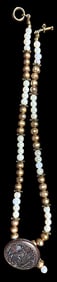 A pearl style beaded necklace with a button