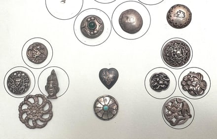 A partial card of assorted silver buttons