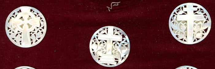 A small card of division three pierced pearl buttons