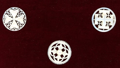 A small card of division three pierced pearl buttons