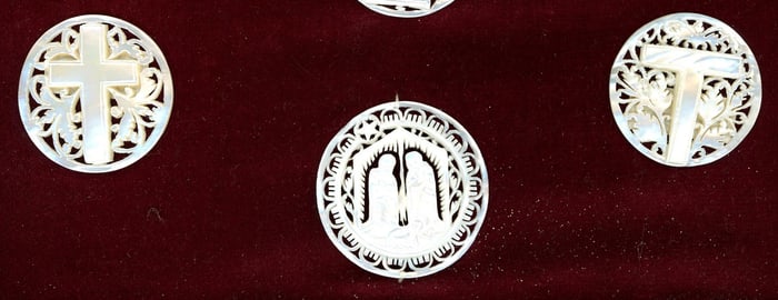 A small card of division three pierced pearl buttons
